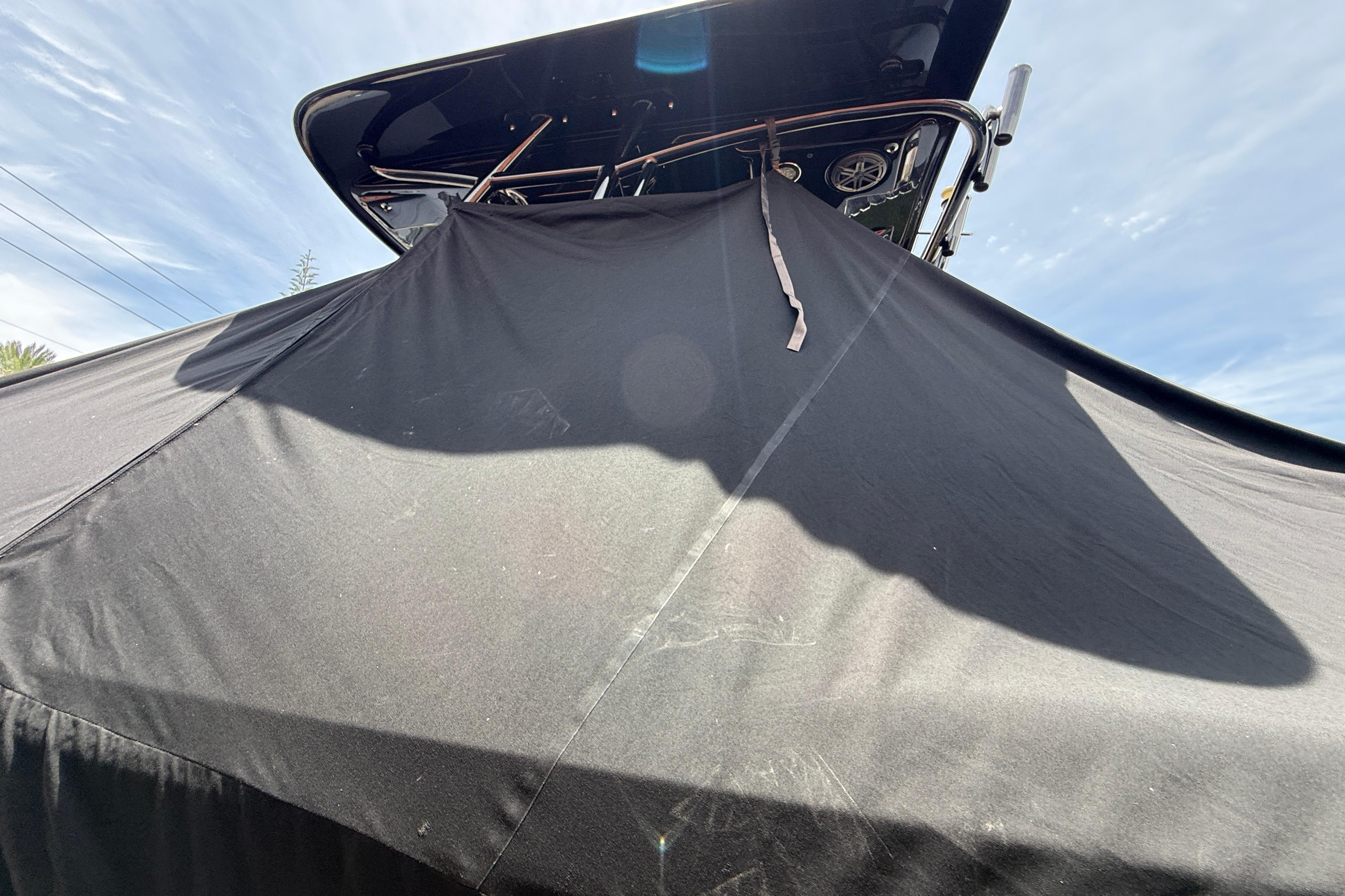 Blackwood 27 boat covered with a black tarp, 2015 model, under a clear sky.