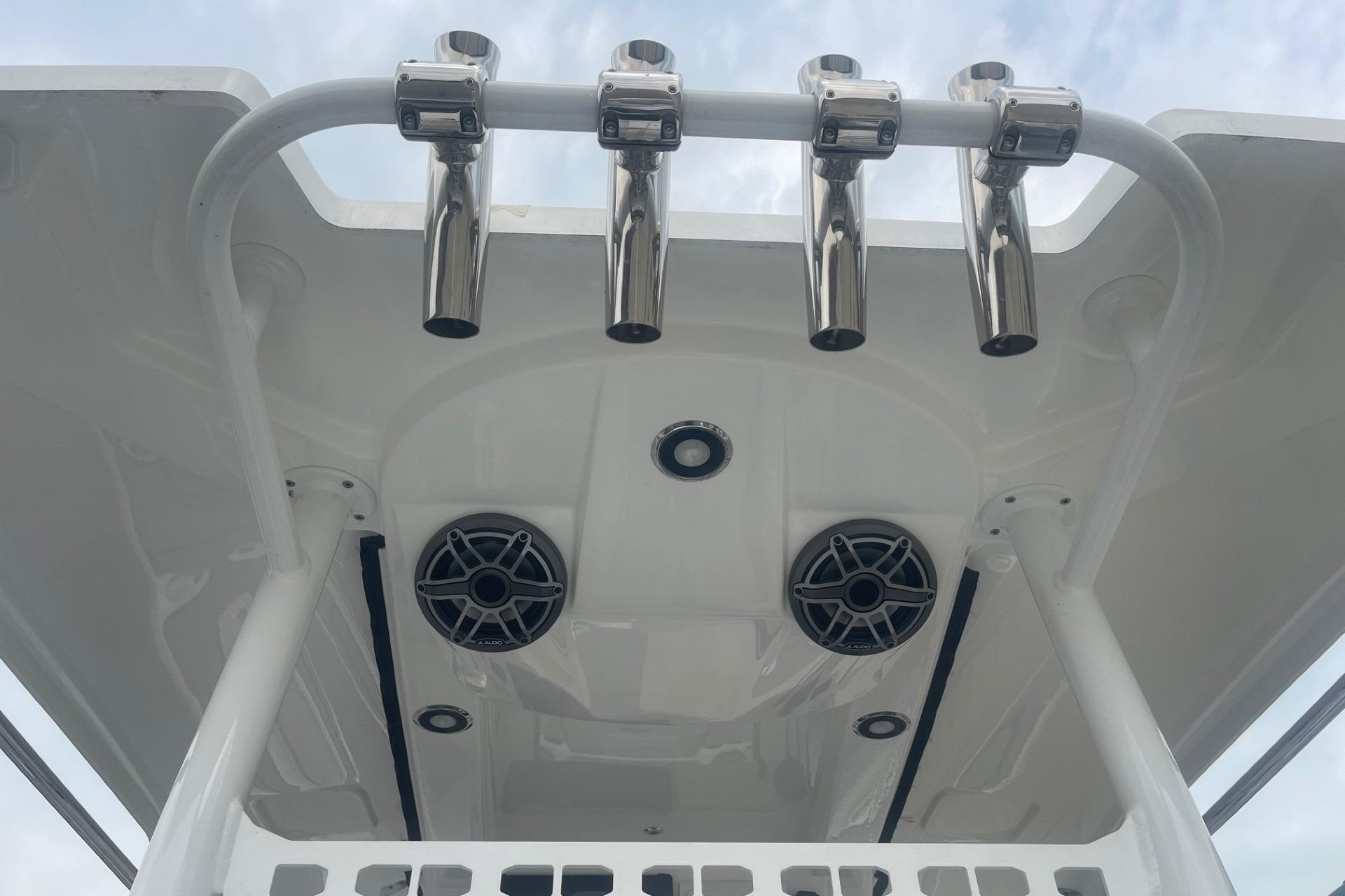 2025 Hurricane Center Console 24 OB boat with rod holders and speakers on the canopy.