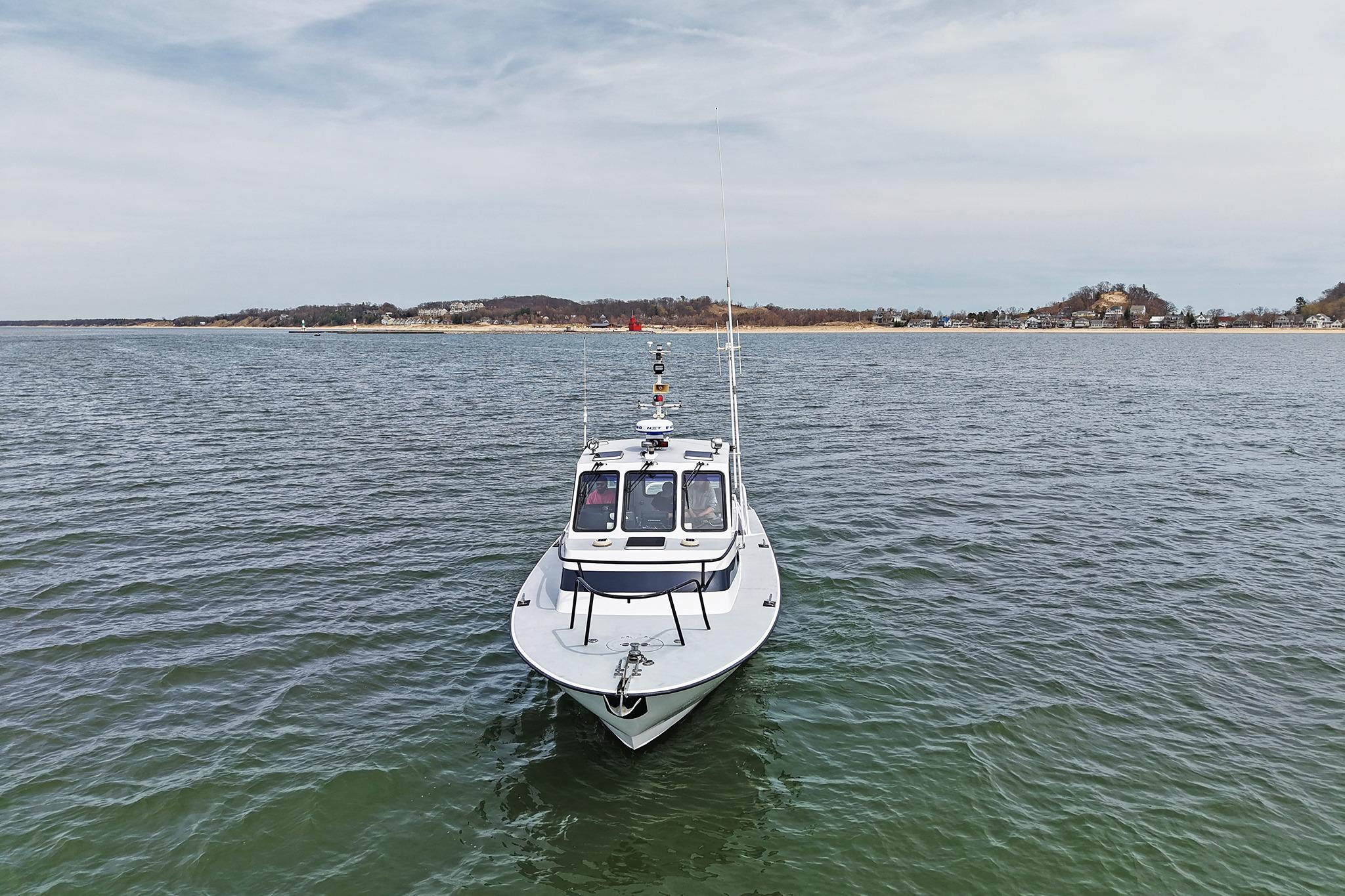 1990 Boston Whaler 36 Defiance boat on calm water with distant shoreline.