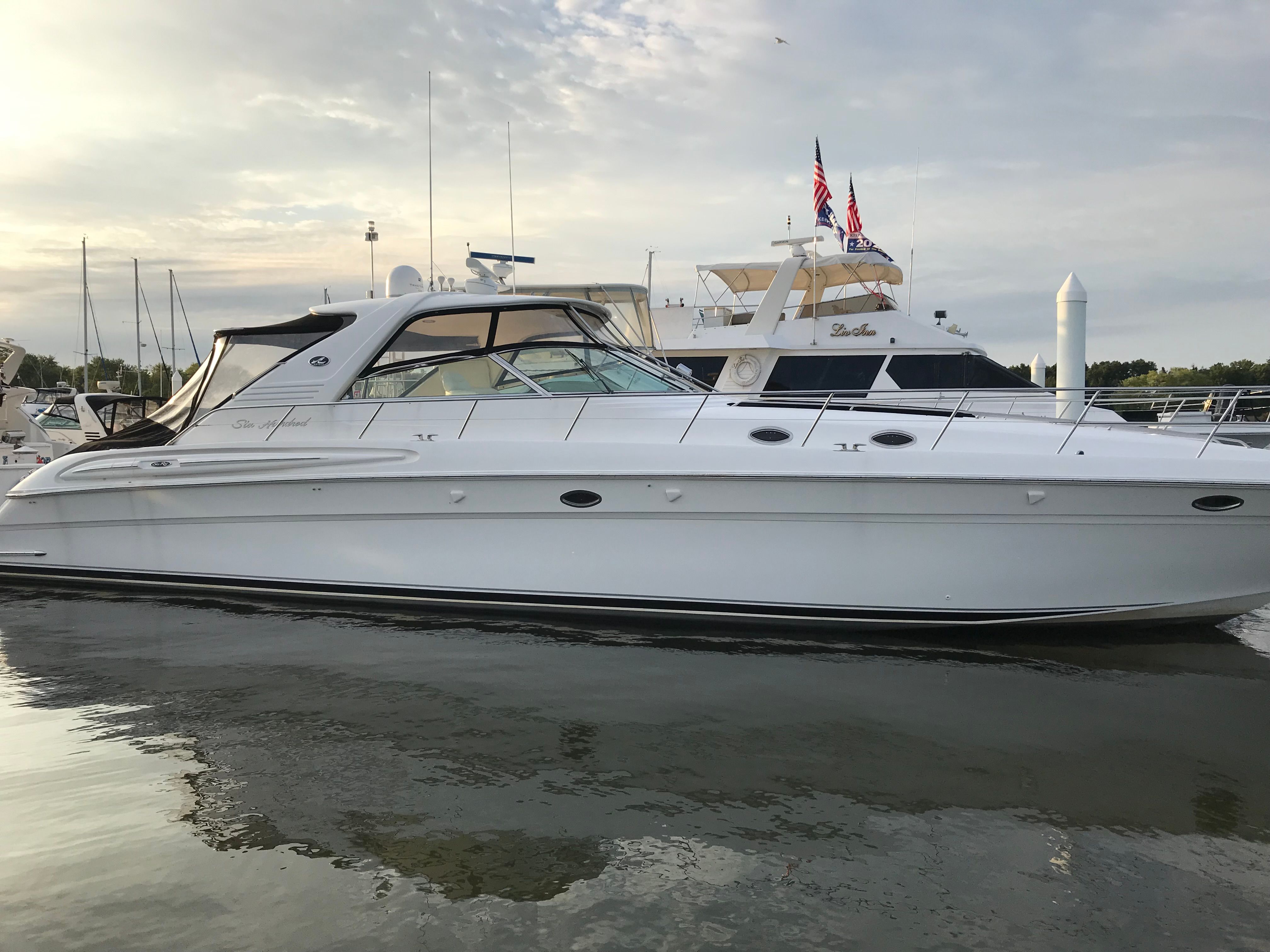 A white 2003 Sea Ray S600 Sunsport is on the water, surrounded by other boats.