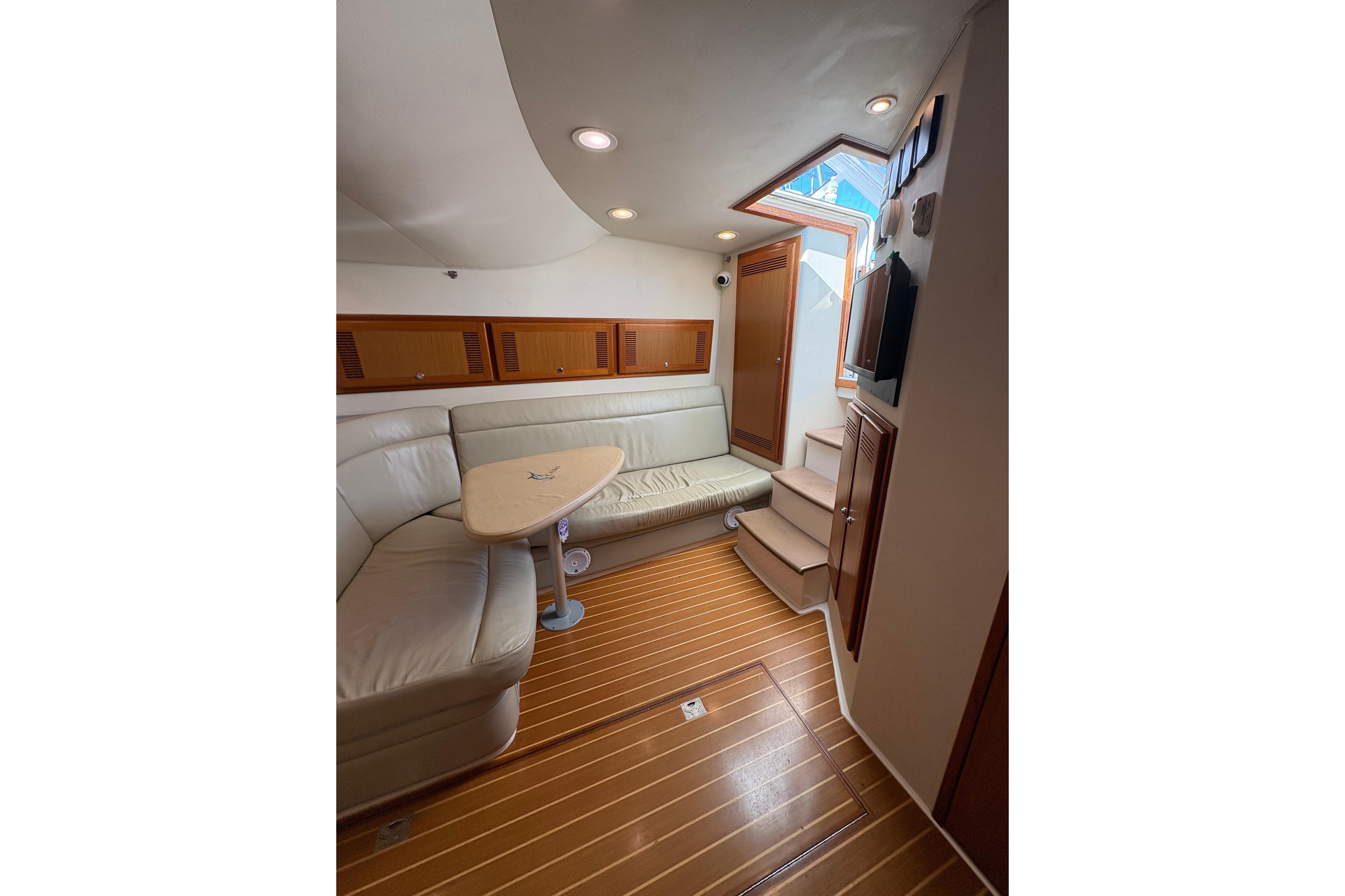 Interior of 2004 Cabo 40 Hardtop Express yacht with leather seating and wooden flooring.