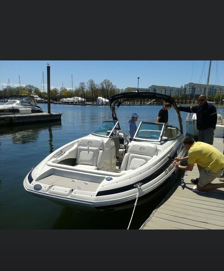 A 2013 Crownline E-4 Bowrider is docked. People are on board and at the dock.