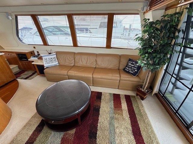 Interior of a 2002 Carver 570 Voyager Pilothouse yacht with leather sofa and rug.