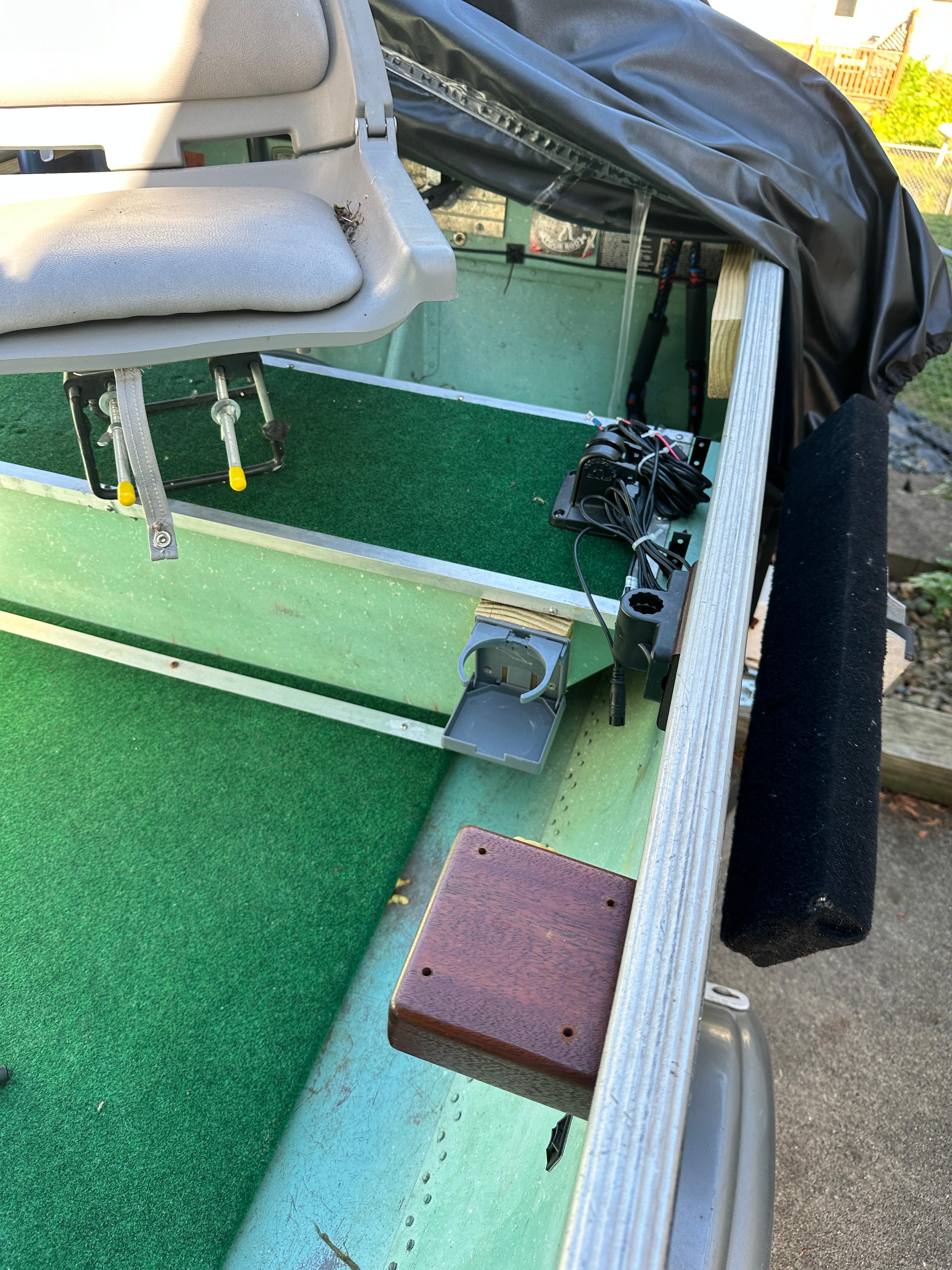 1960 Lund H boat interior with green carpet and mounted seat.