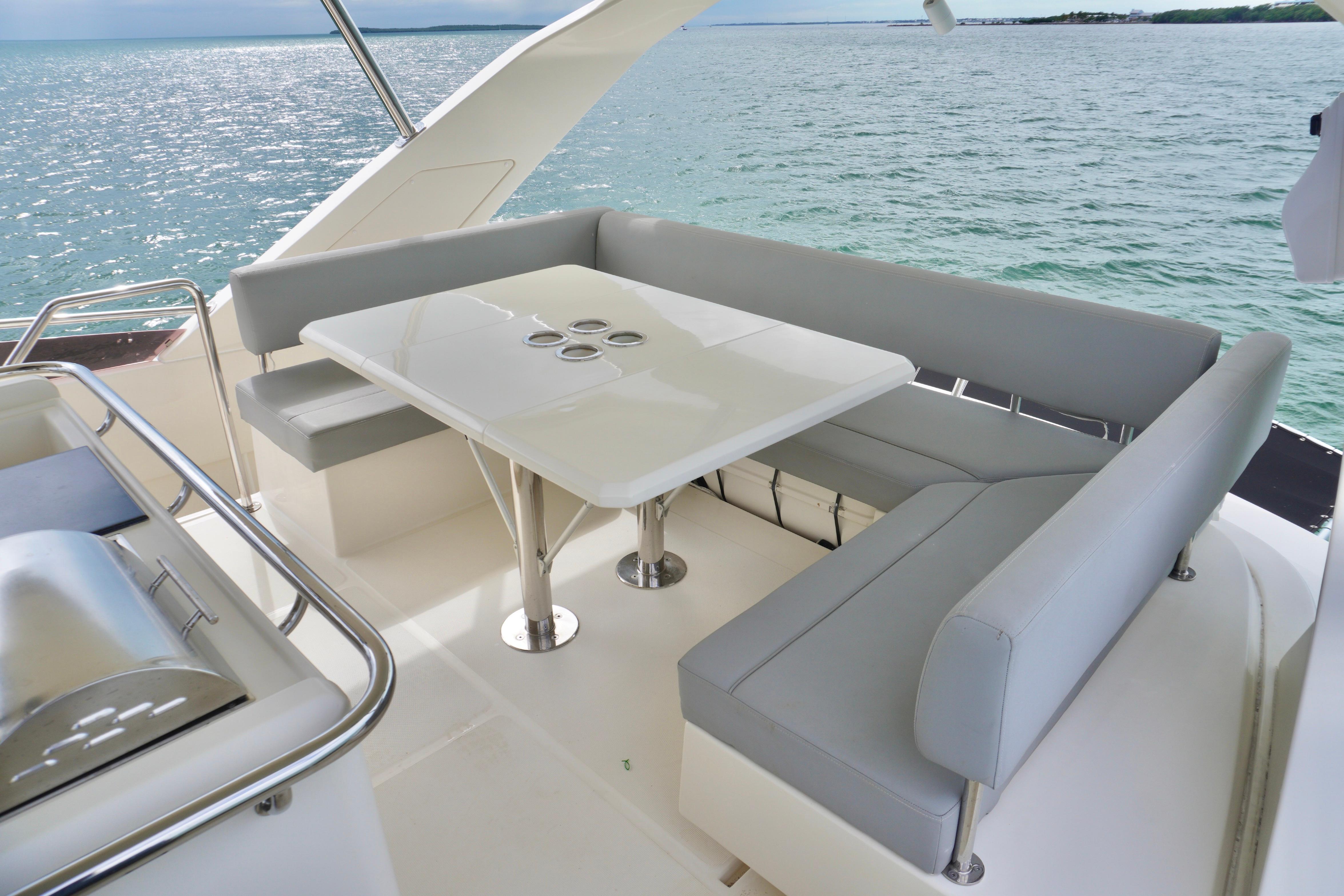 2017 Aquila 44 Yacht with elegant outdoor seating and table, overlooking serene ocean waters.