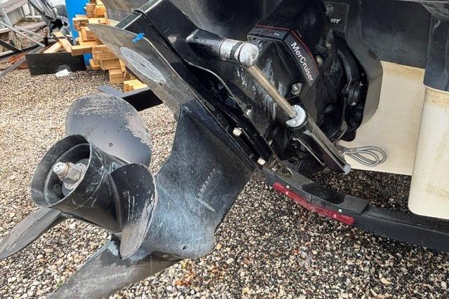 2021 Chaparral 21 SSi boat's outboard motor and propeller on gravel surface.