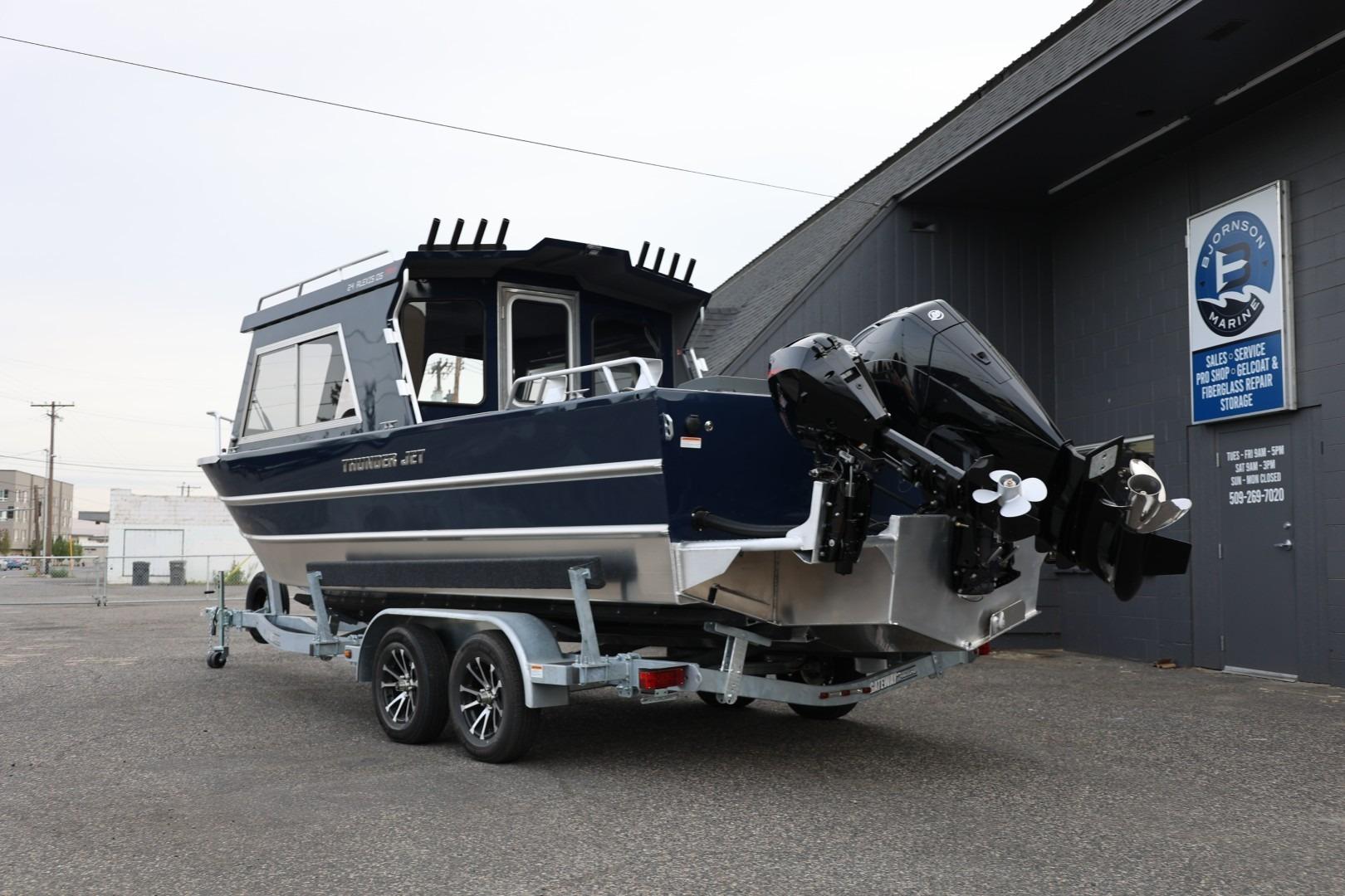 2026 Thunder Jet 24 Alexis Pro boat on trailer outside marine service shop.