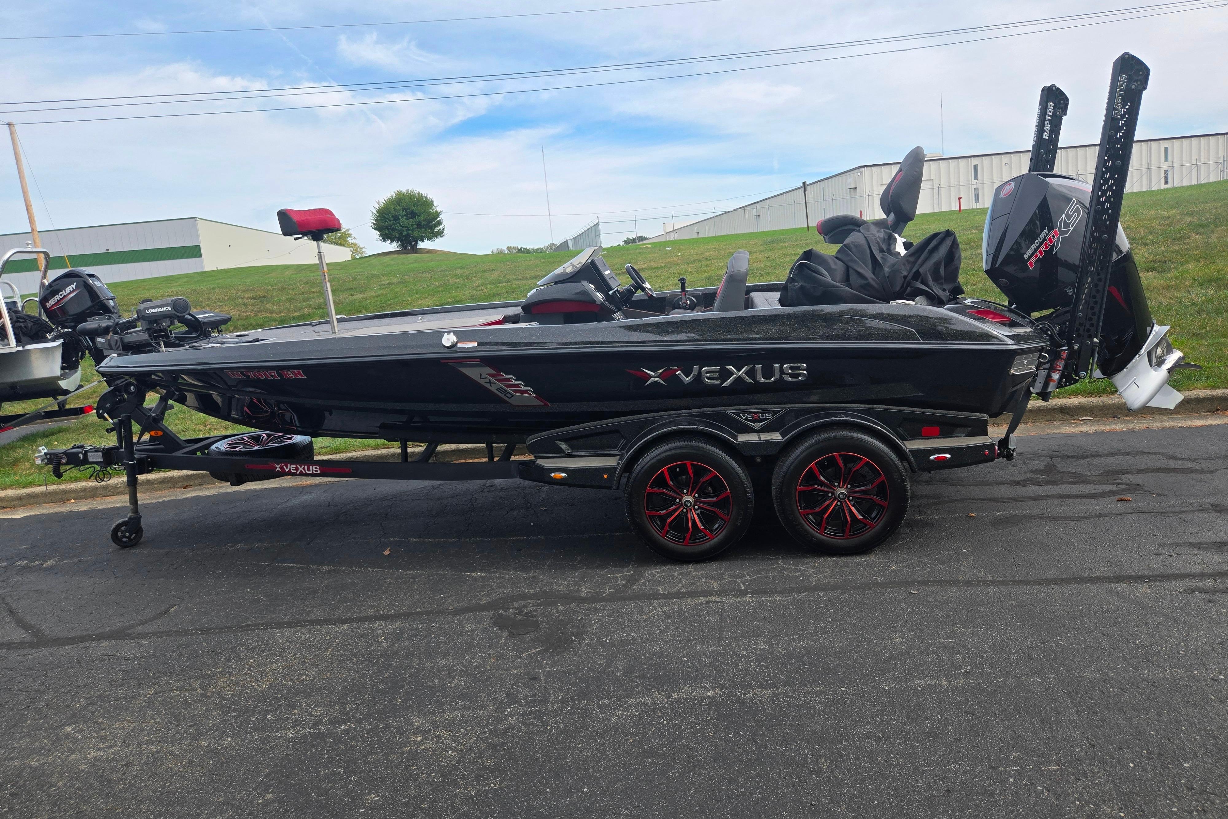2022 Vexus VX20 boat on trailer, black with red accents, parked outdoors.