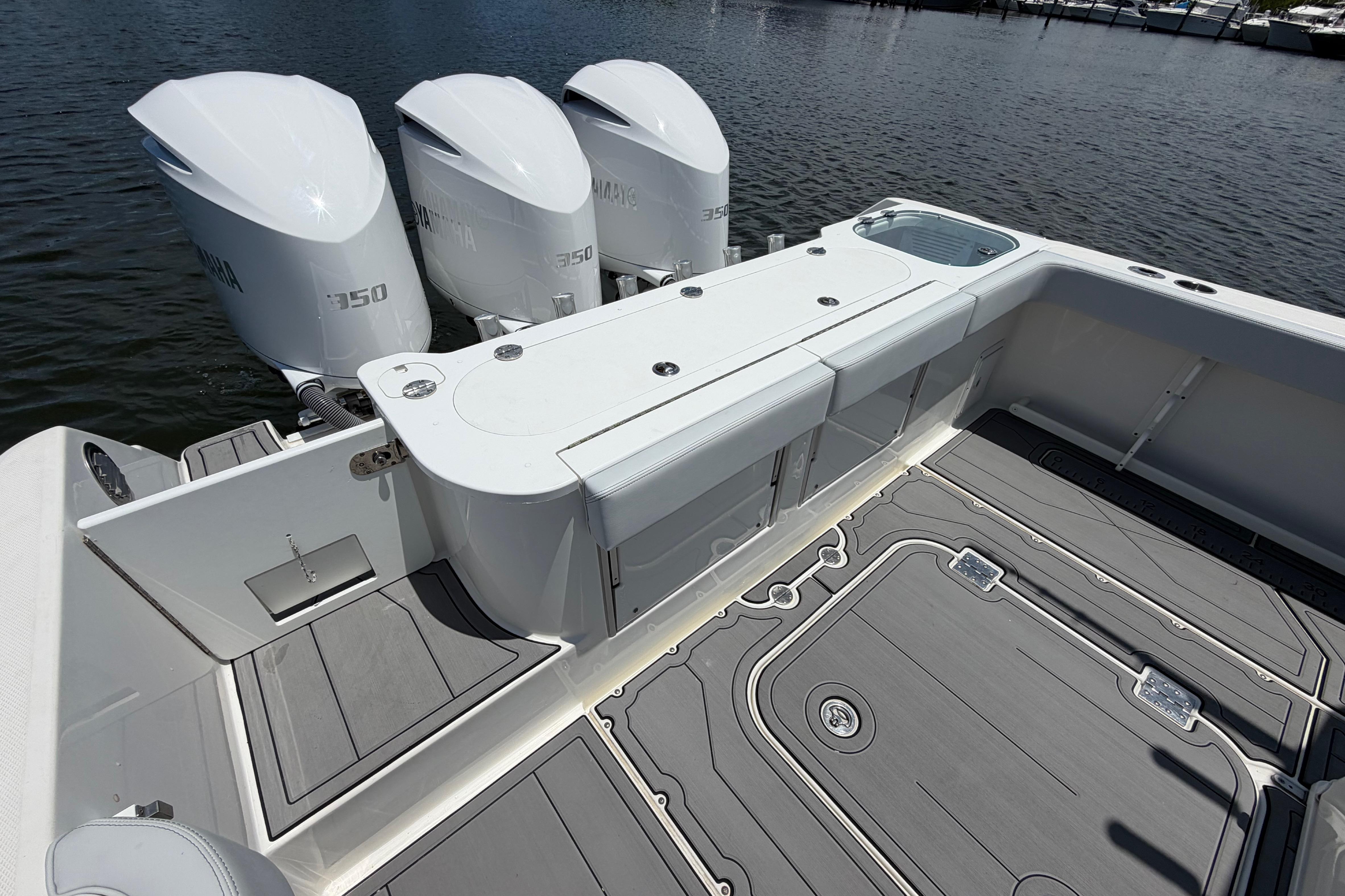 2009 Everglades 350LX boat with triple Yamaha 350 engines, docked on calm water.