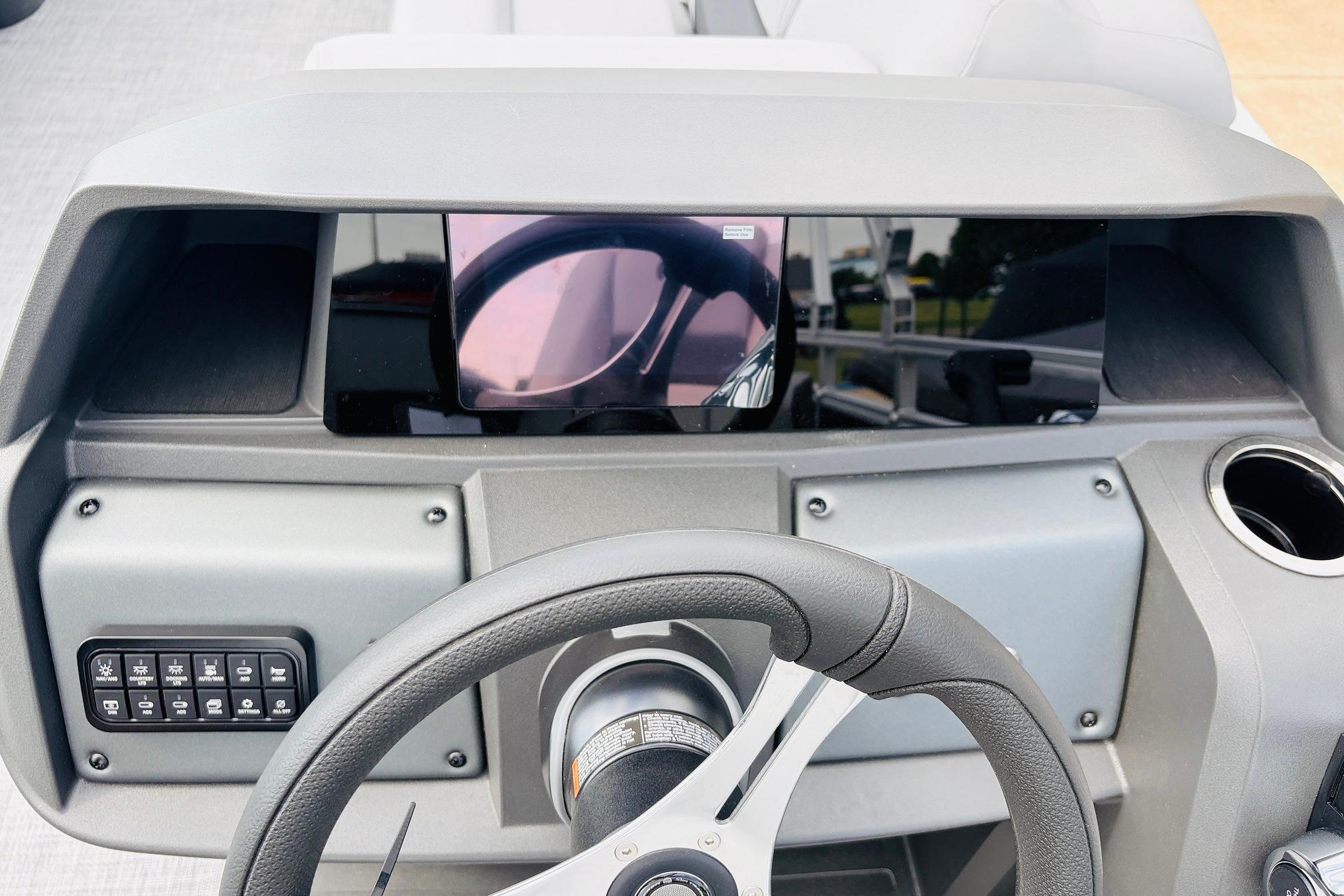 2026 Sun Tracker SportFish 22 DLX dashboard with steering wheel and digital display.