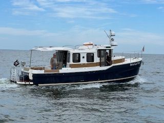 2023 Ranger Tugs R 31 le on the water with a blue hull and white superstructure.