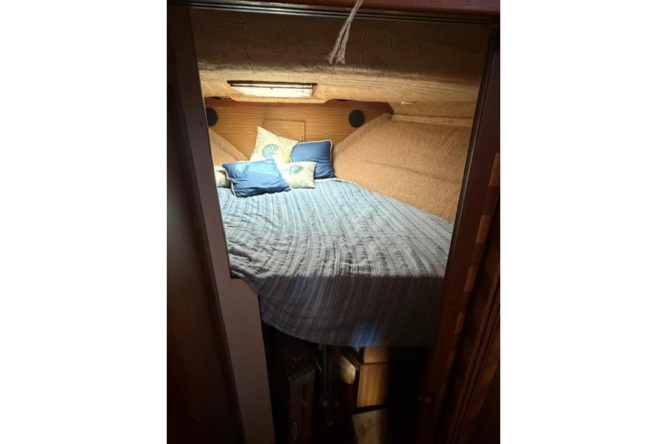 Cozy cabin interior of 1980 Chris-Craft 381 Catalina with bed and pillows.