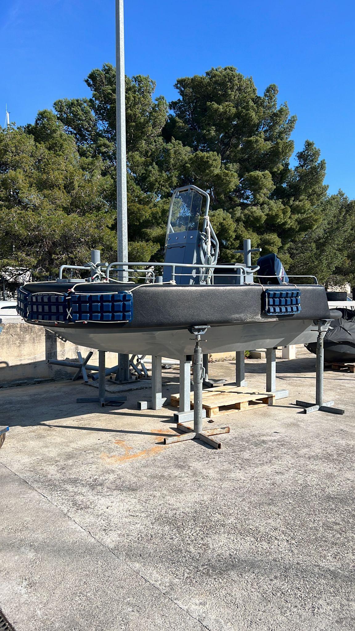 2023 3D Tender Pilot 420 boat on stands, surrounded by trees and clear blue sky.