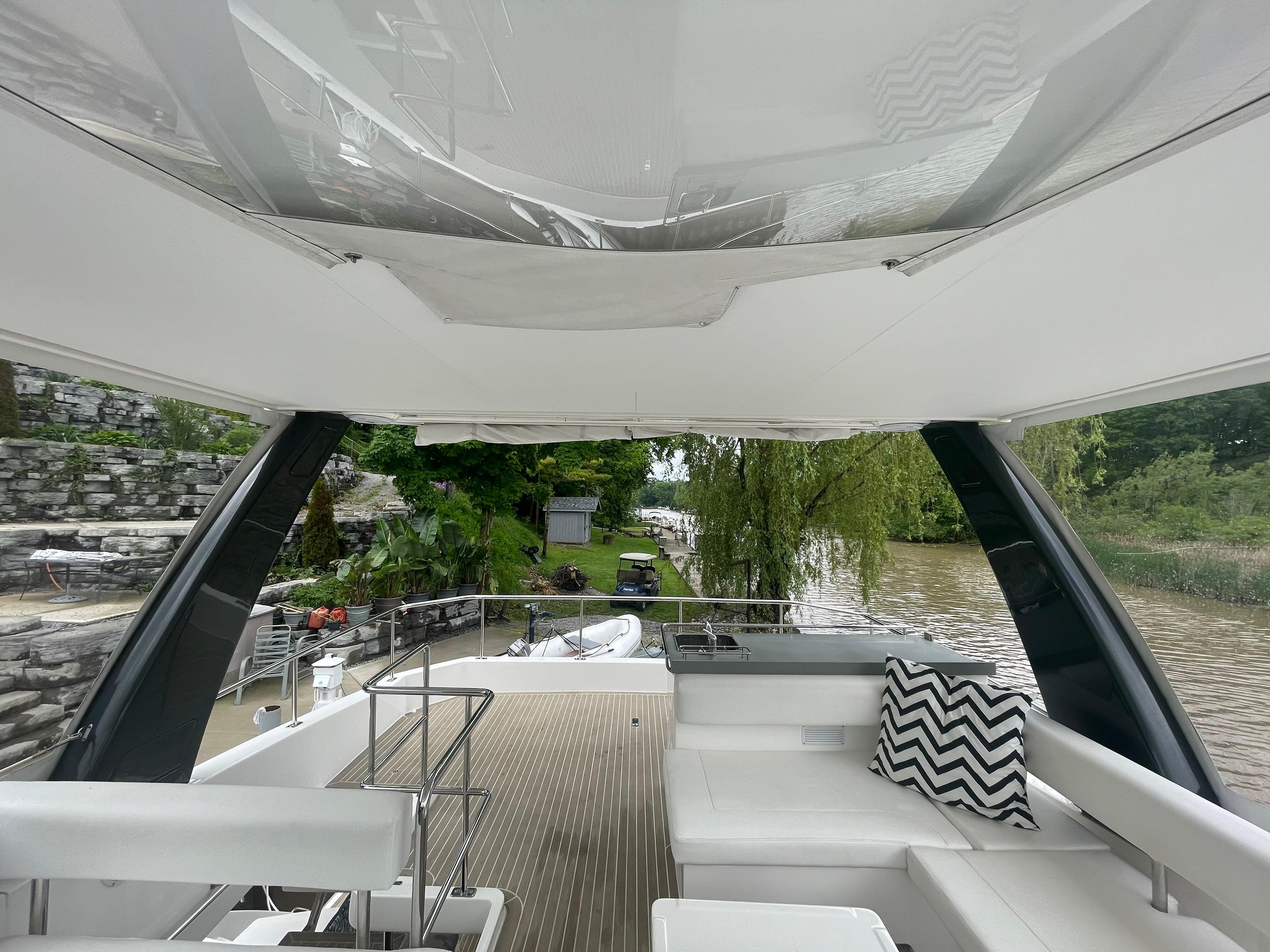 Interior view of 2020 Leopard 43 Powercat yacht with white seating and scenic waterway.