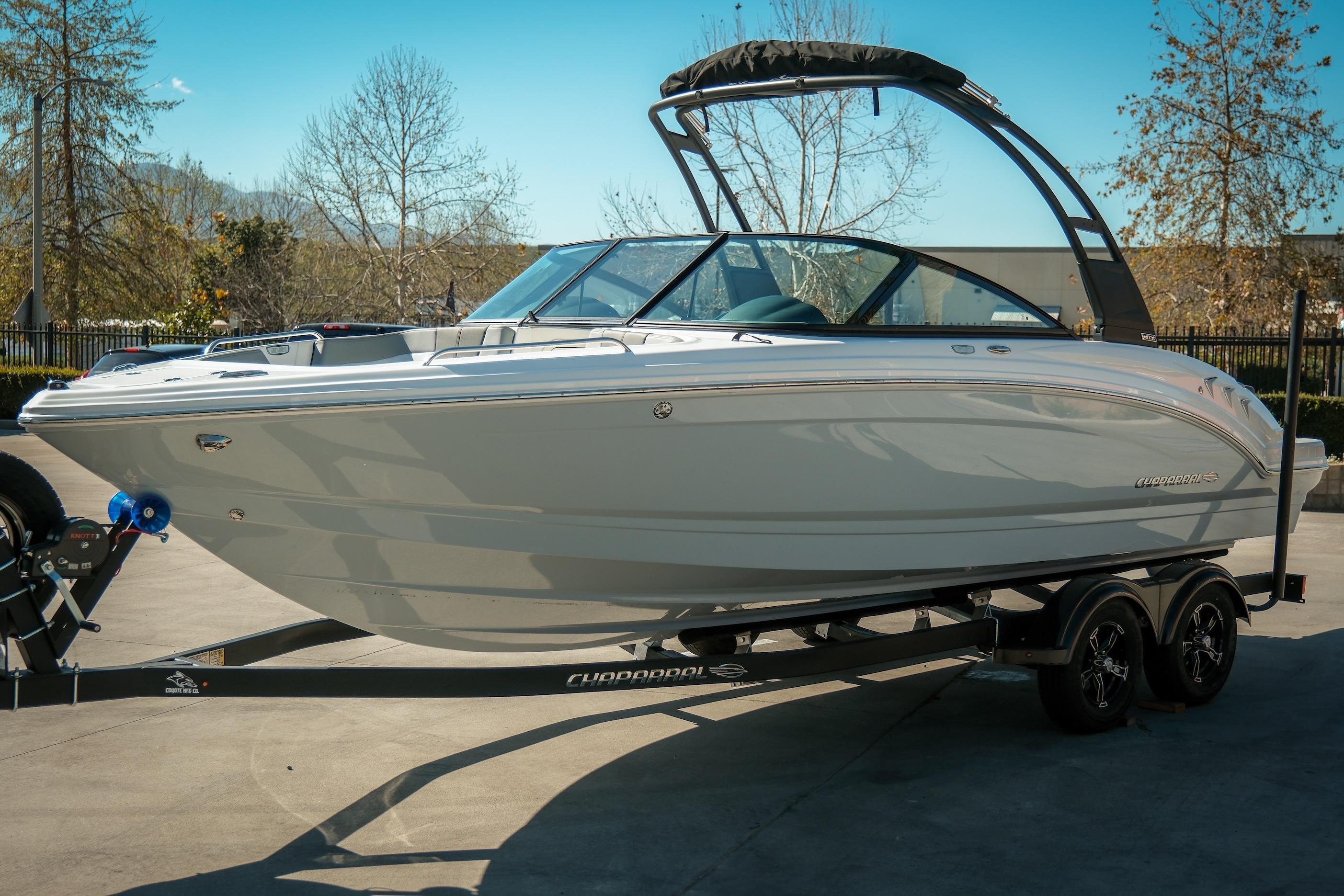 2026 Chaparral 23 SSi boat on trailer, parked outdoors on a sunny day.