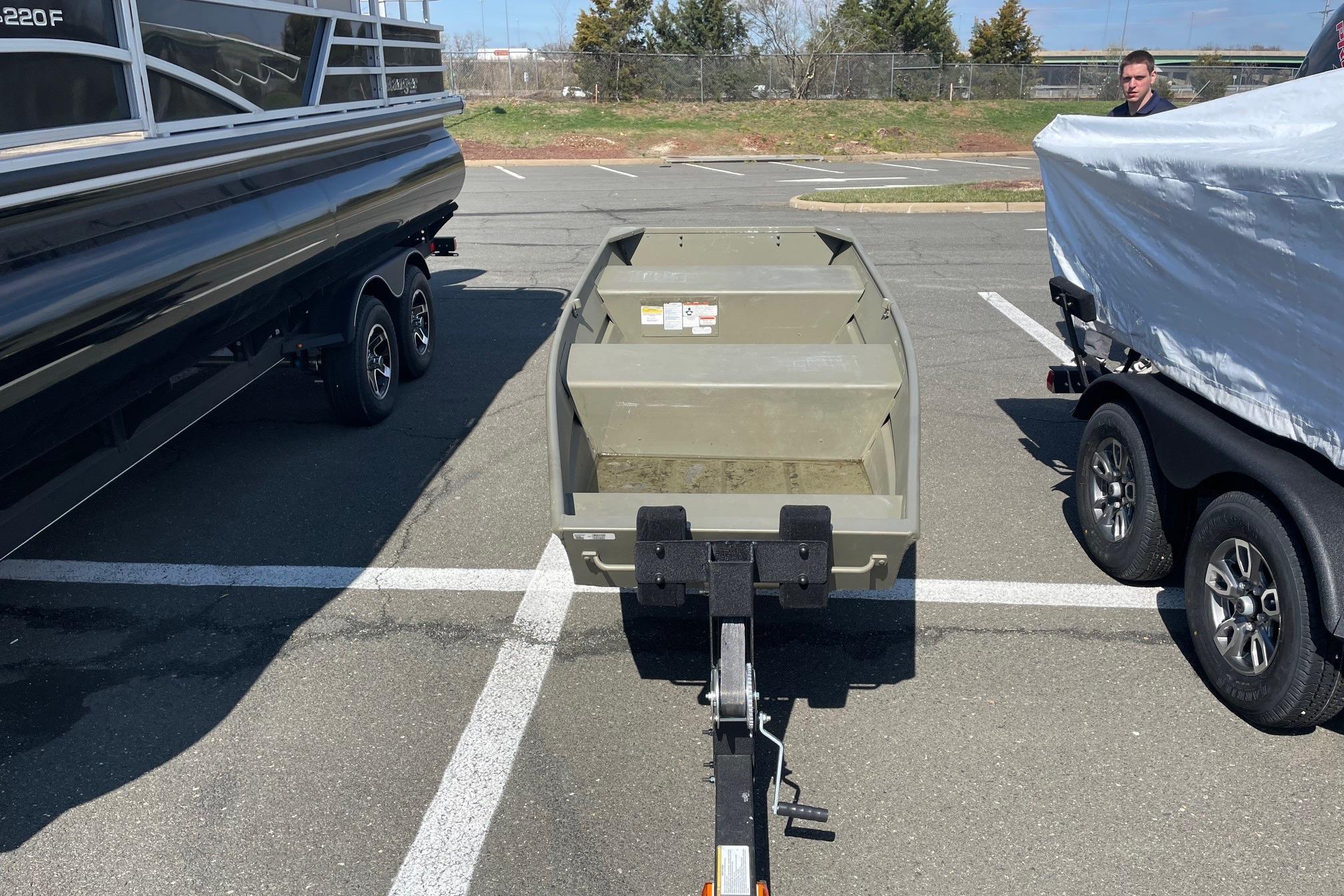 2025 Tracker Grizzly 1236 Jon boat on trailer in parking lot.