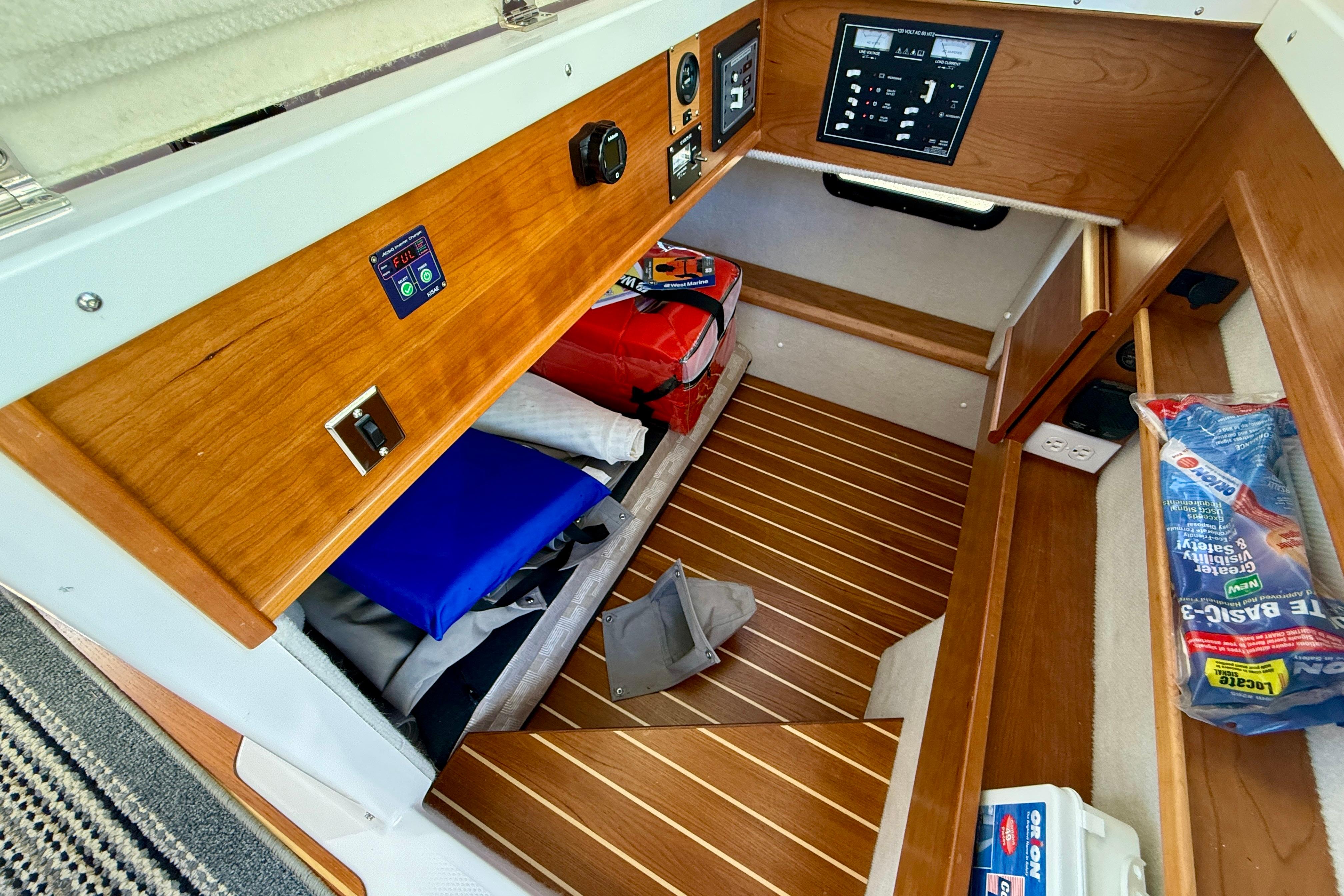 2023 Cutwater C-30 Sedan interior storage with wooden paneling and safety equipment.