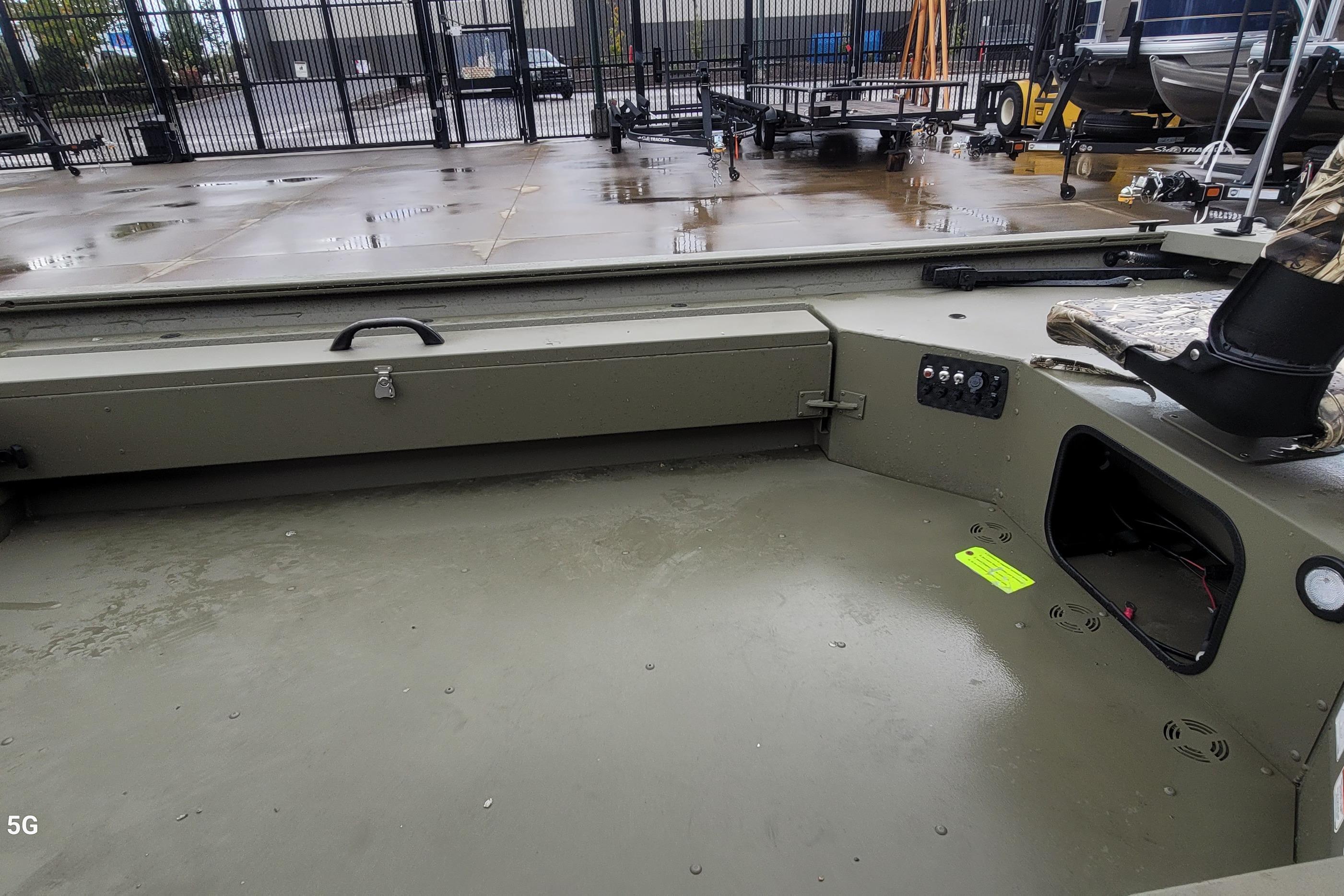 2026 Tracker Grizzly 1654 T Sportsman boat interior with storage and control panel.