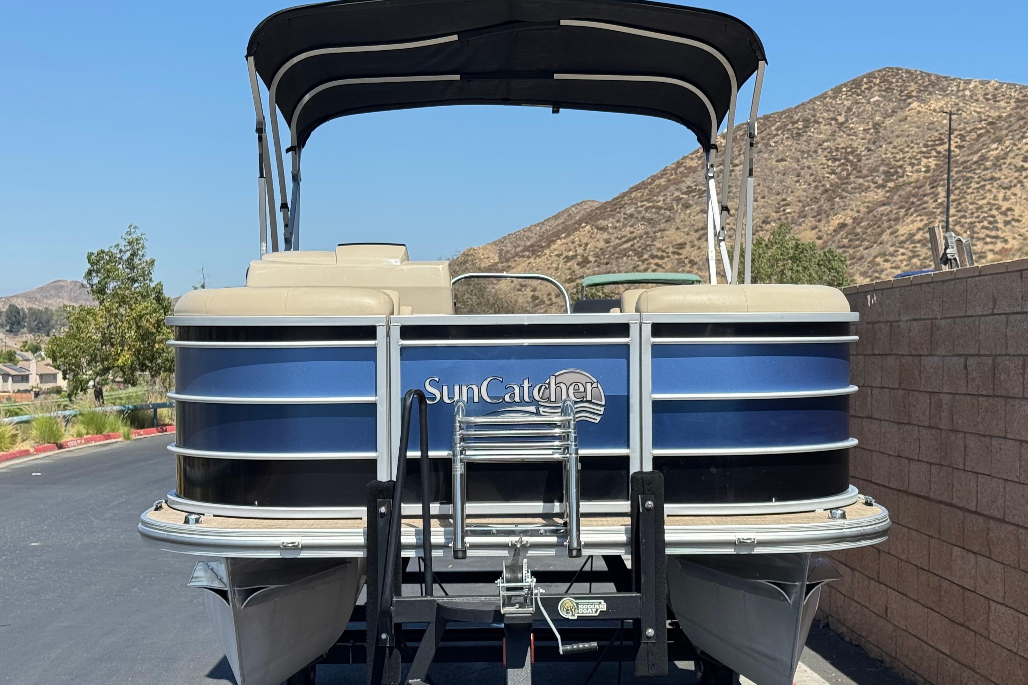 2021 SunCatcher Select 20RCX pontoon boat with canopy, parked on a sunny day.
