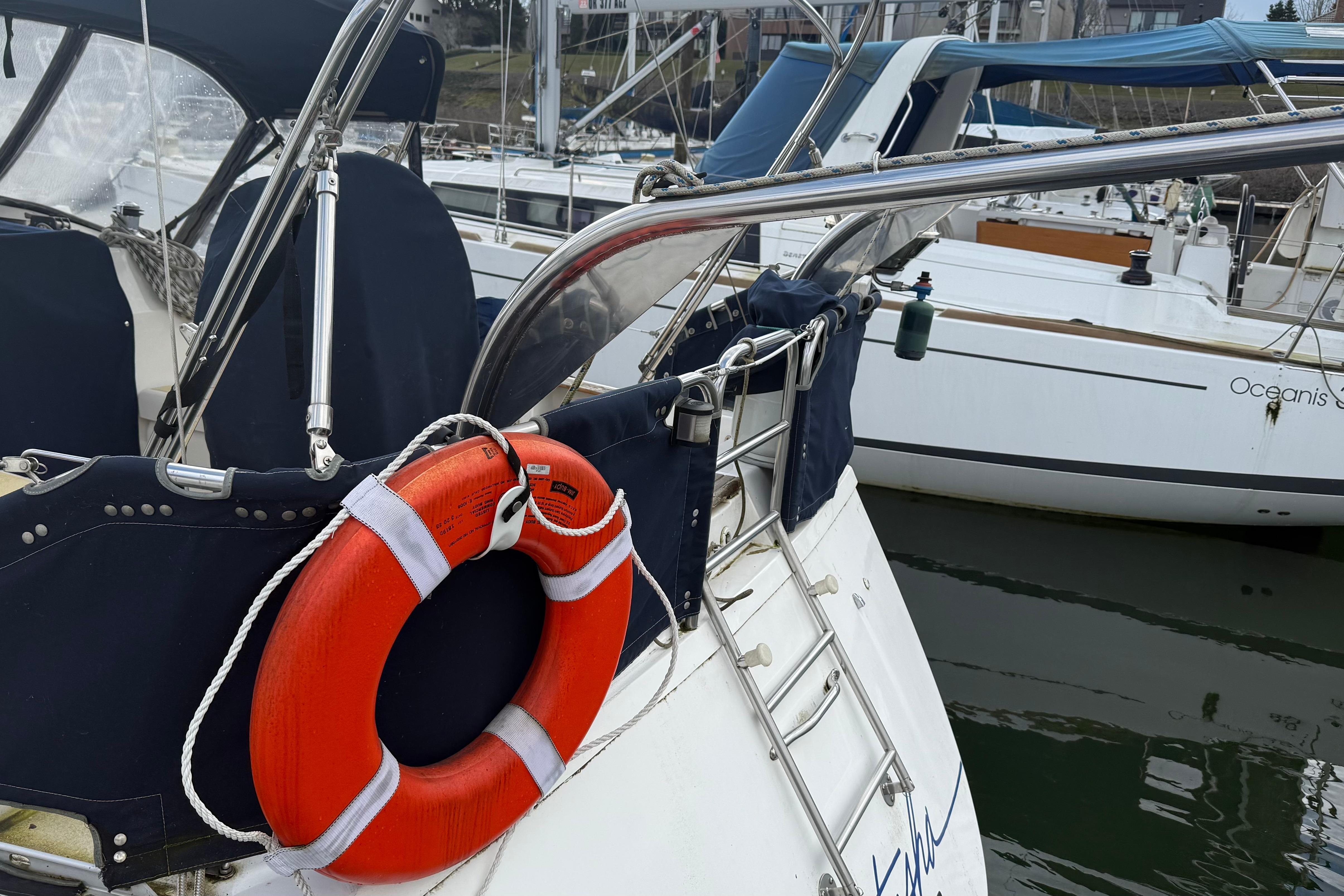 1984 Hunter 31 sailboat with lifebuoy, docked in marina.