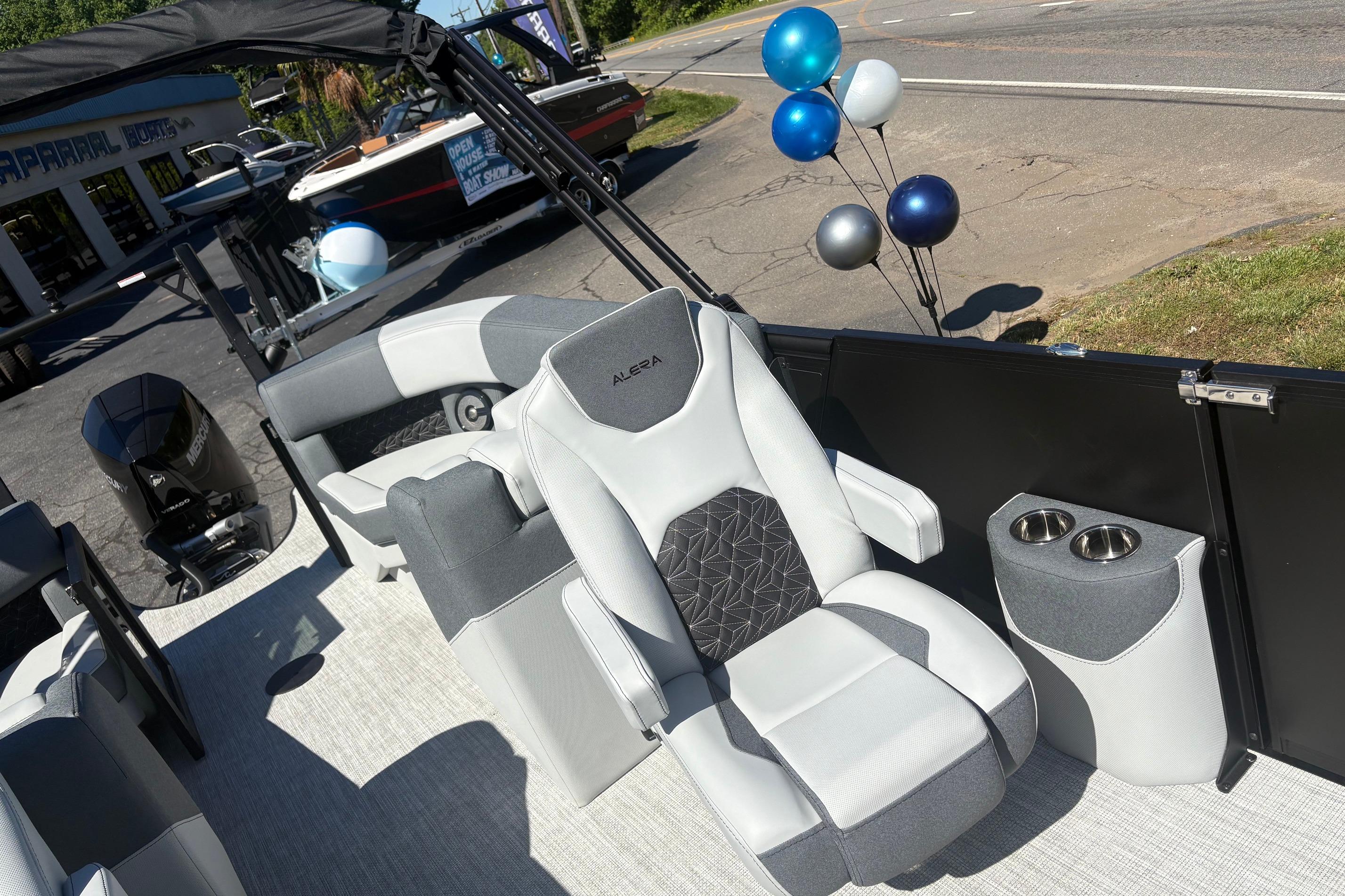 2026 Alera 23Q boat interior with plush seating and cup holders, displayed outdoors with balloons.