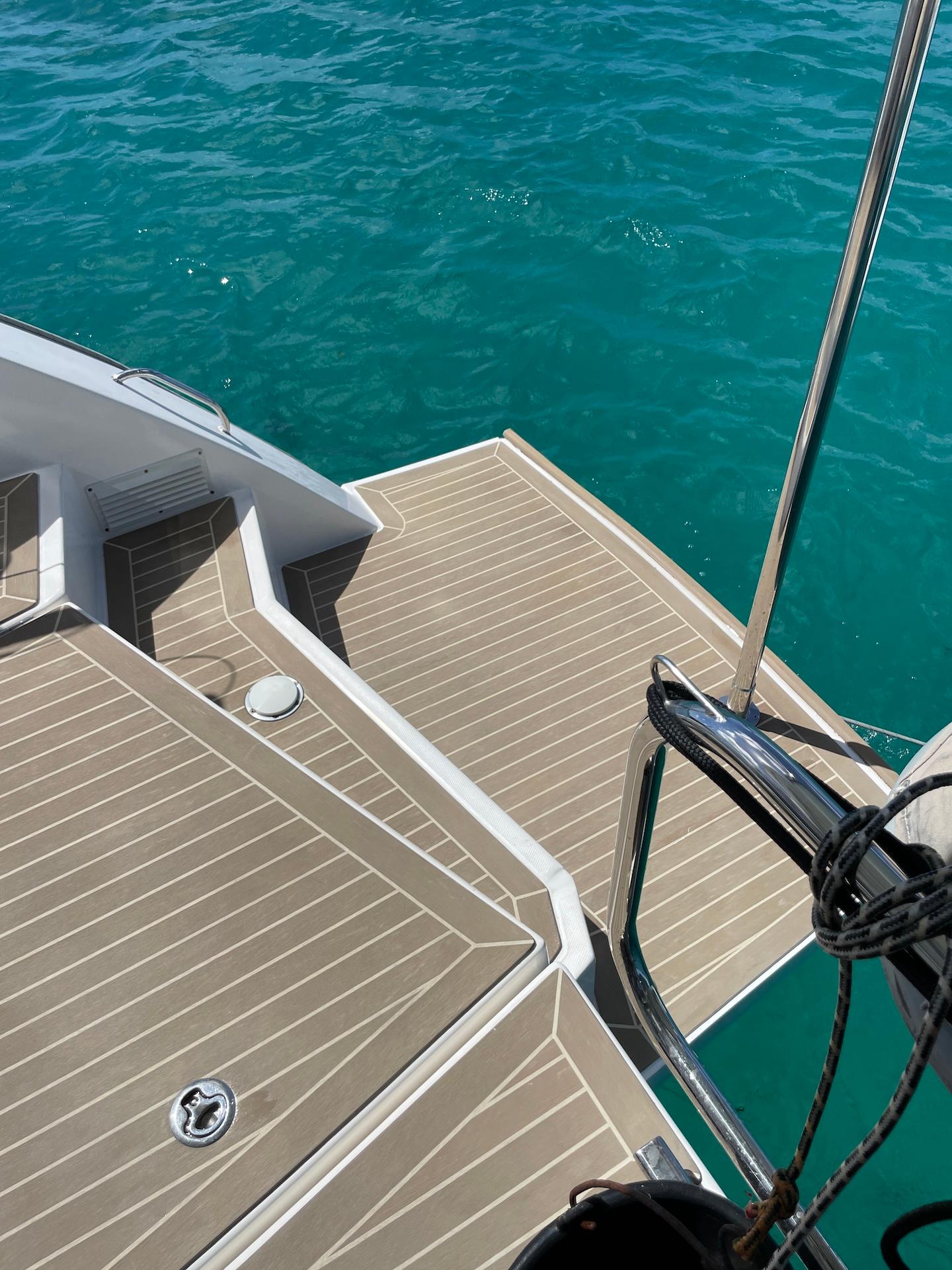 Leopard 45 yacht deck with teak flooring, overlooking clear turquoise water.
