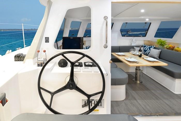 Interior of 2025 Seawind 1170 catamaran with helm and dining area.