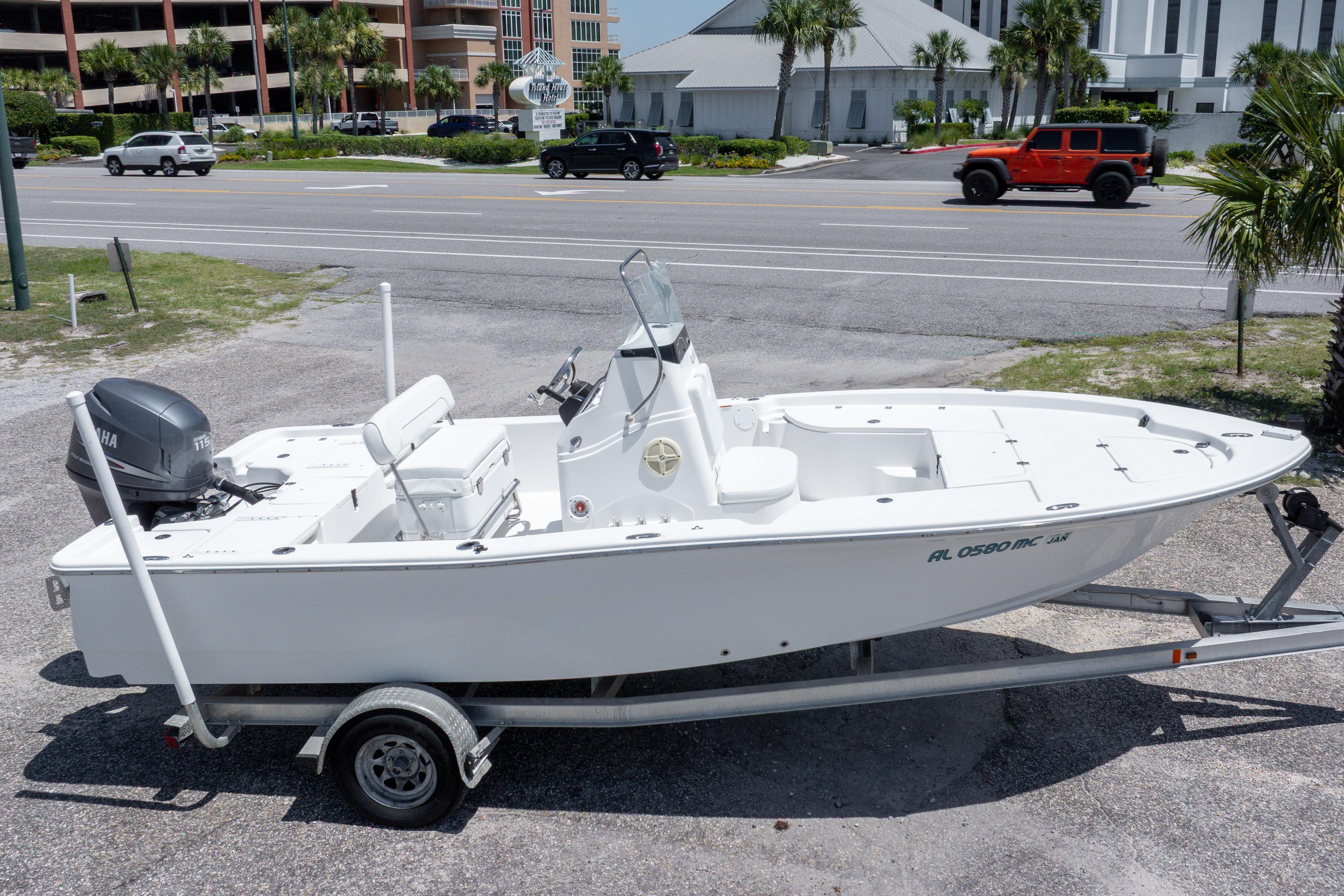 2011 Sea Fox 200XT boat on trailer, parked near a road with palm trees.