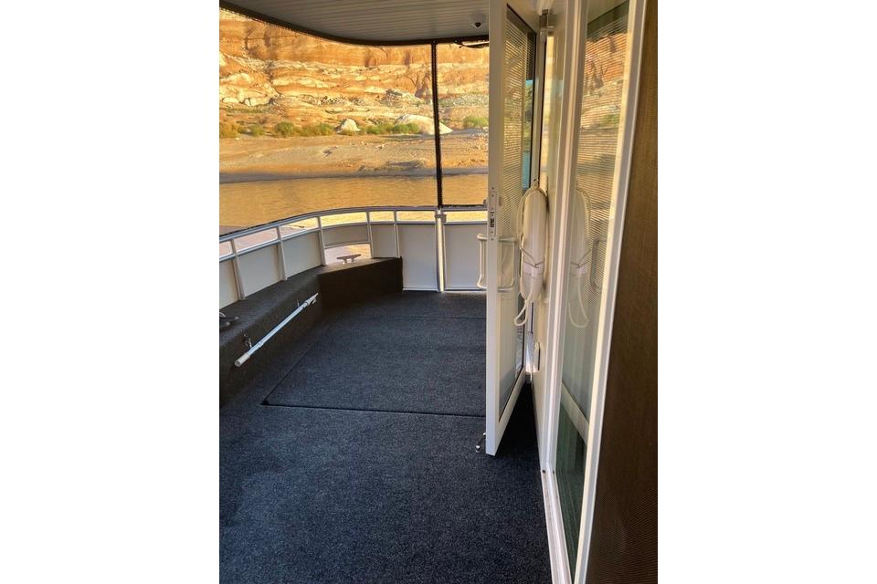 Boat deck with open doors, overlooking scenic rocky landscape. Adonia, The Queen Elizabeth, 2021.