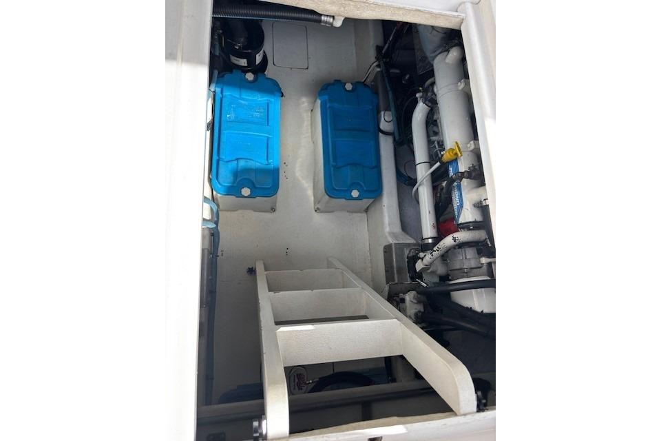 Engine compartment of a 2004 Canoe Cove Sedan with blue components and white piping.