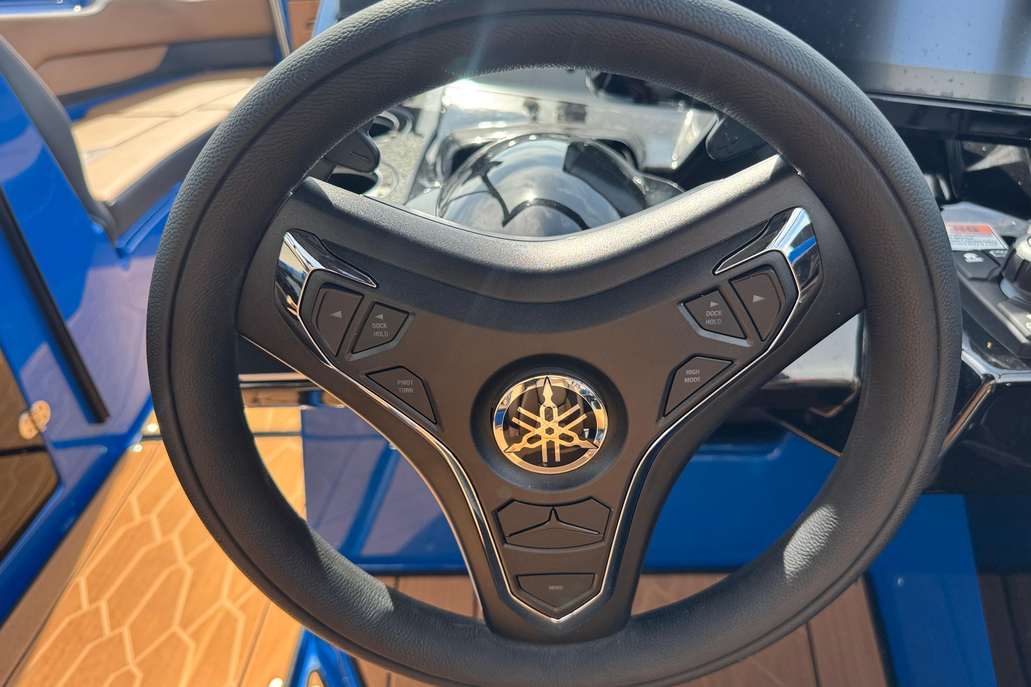 Steering wheel of 2026 Yamaha Boats 255XD, featuring control buttons and sleek design.