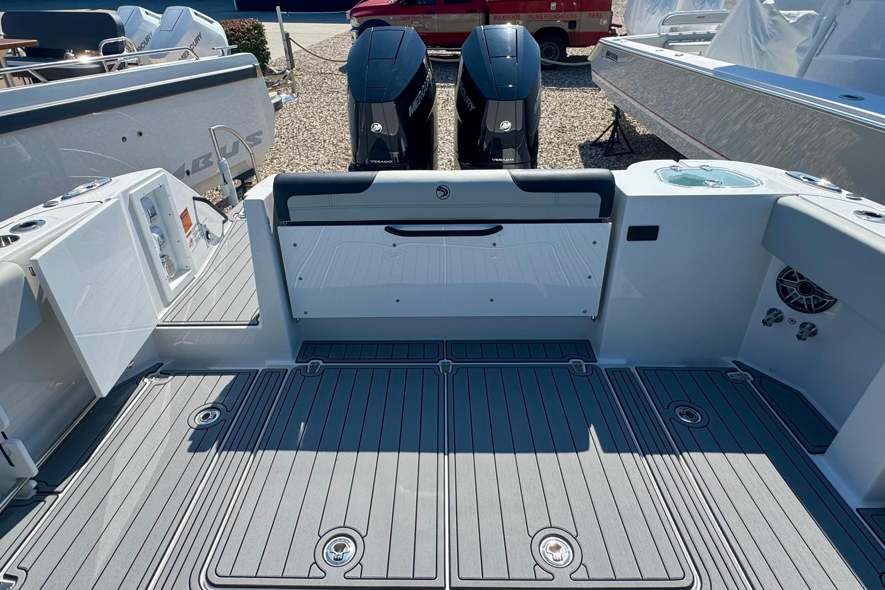 2025 Edgewater 340CC boat deck with twin outboard engines, featuring sleek design and modern amenities.