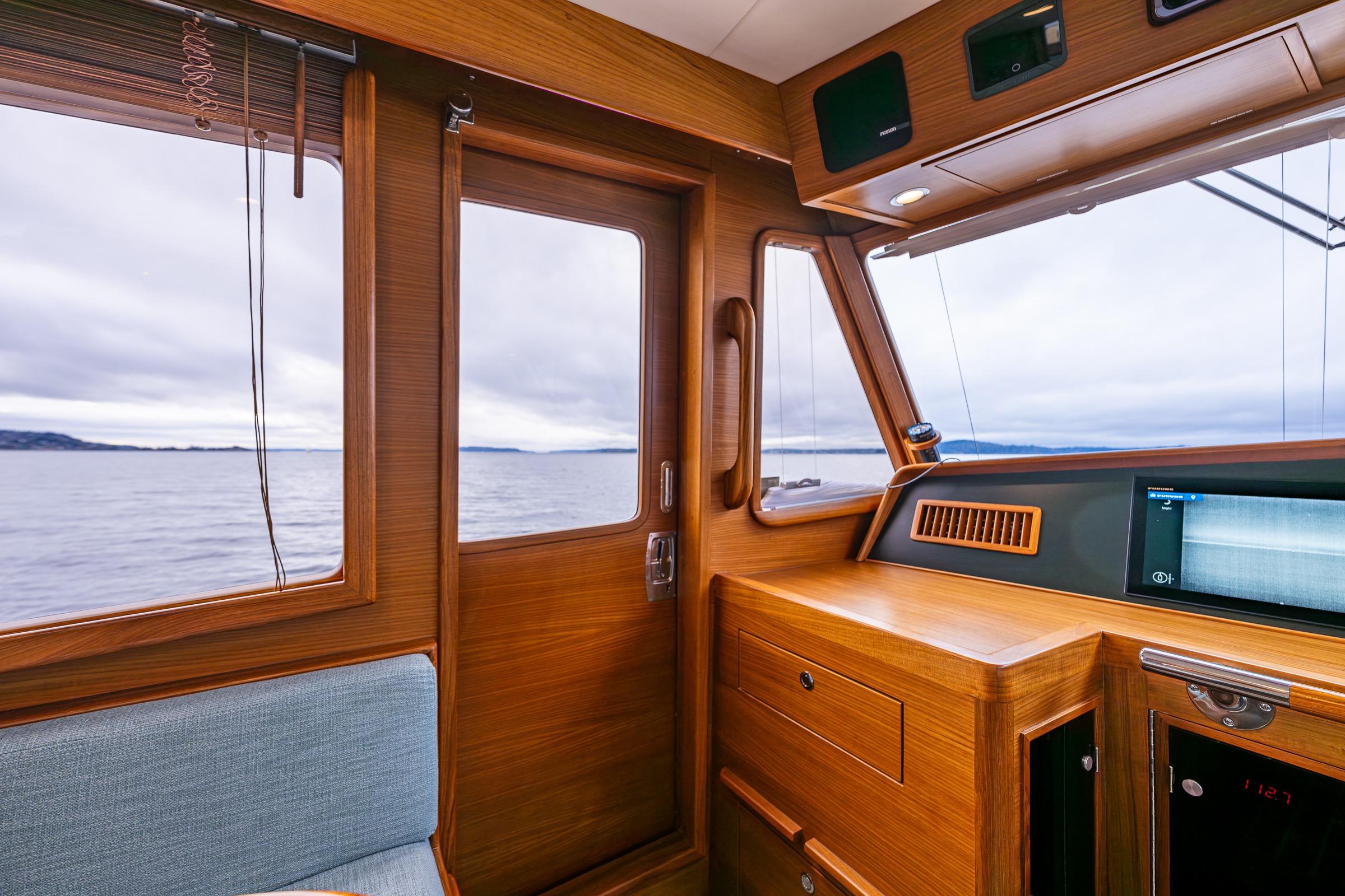 Interior of 2026 Fleming 55 Pilothouse yacht with wooden finish and ocean view.