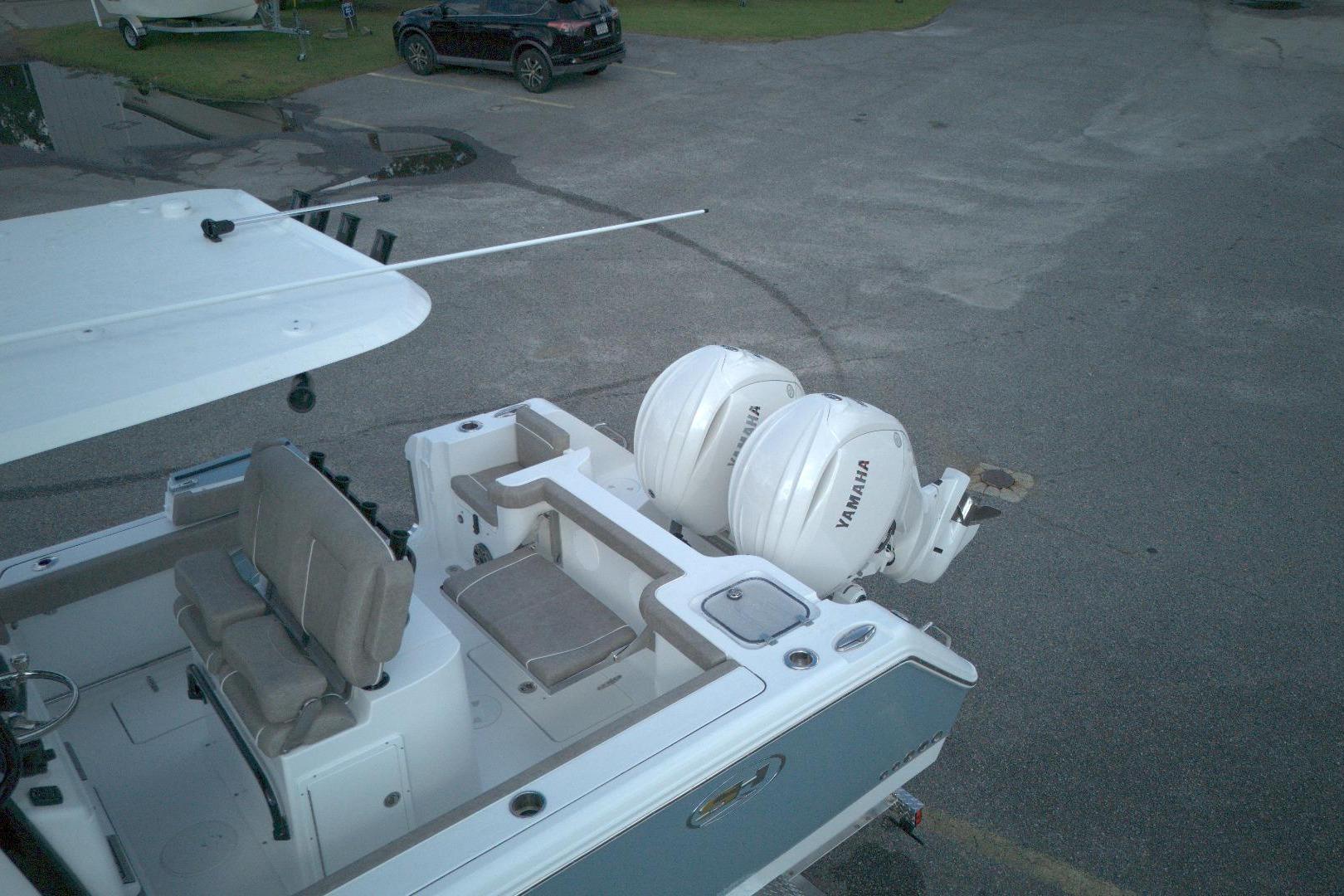2026 Sea Hunt Gamefish 25 boat with dual Yamaha engines, parked on pavement.