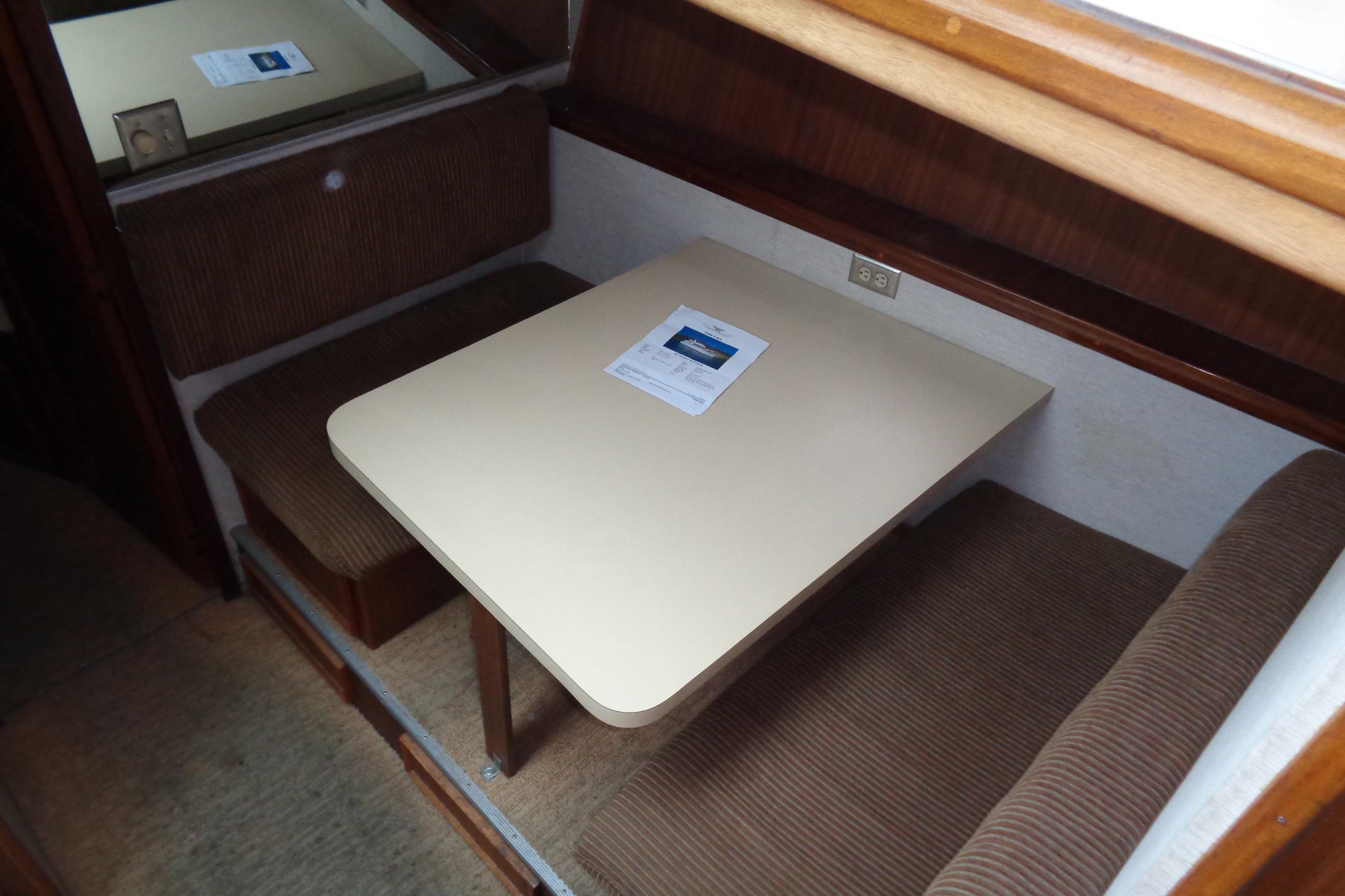 1981 Hatteras 48 Cockpit Motor Yacht interior dining area with table and cushioned seating.
