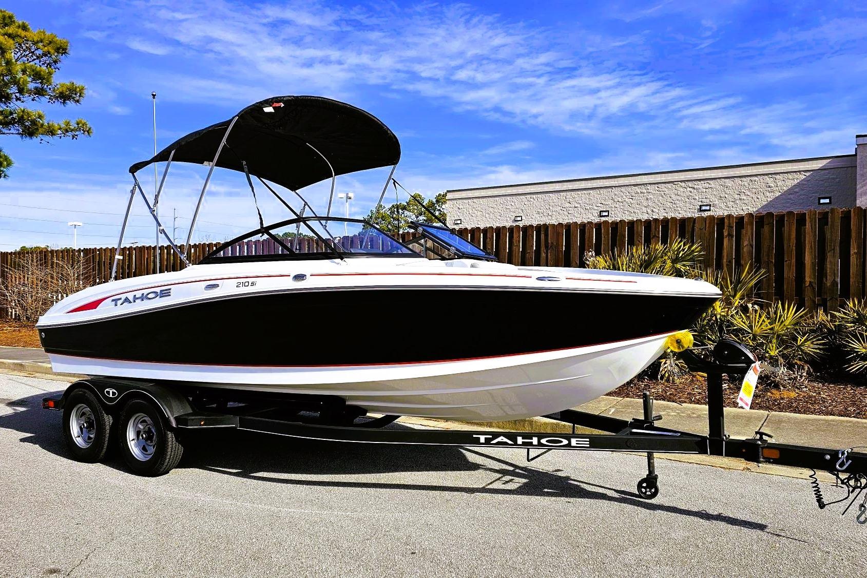 2023 Tahoe 210 Si boat on trailer, black and white design, parked outdoors.