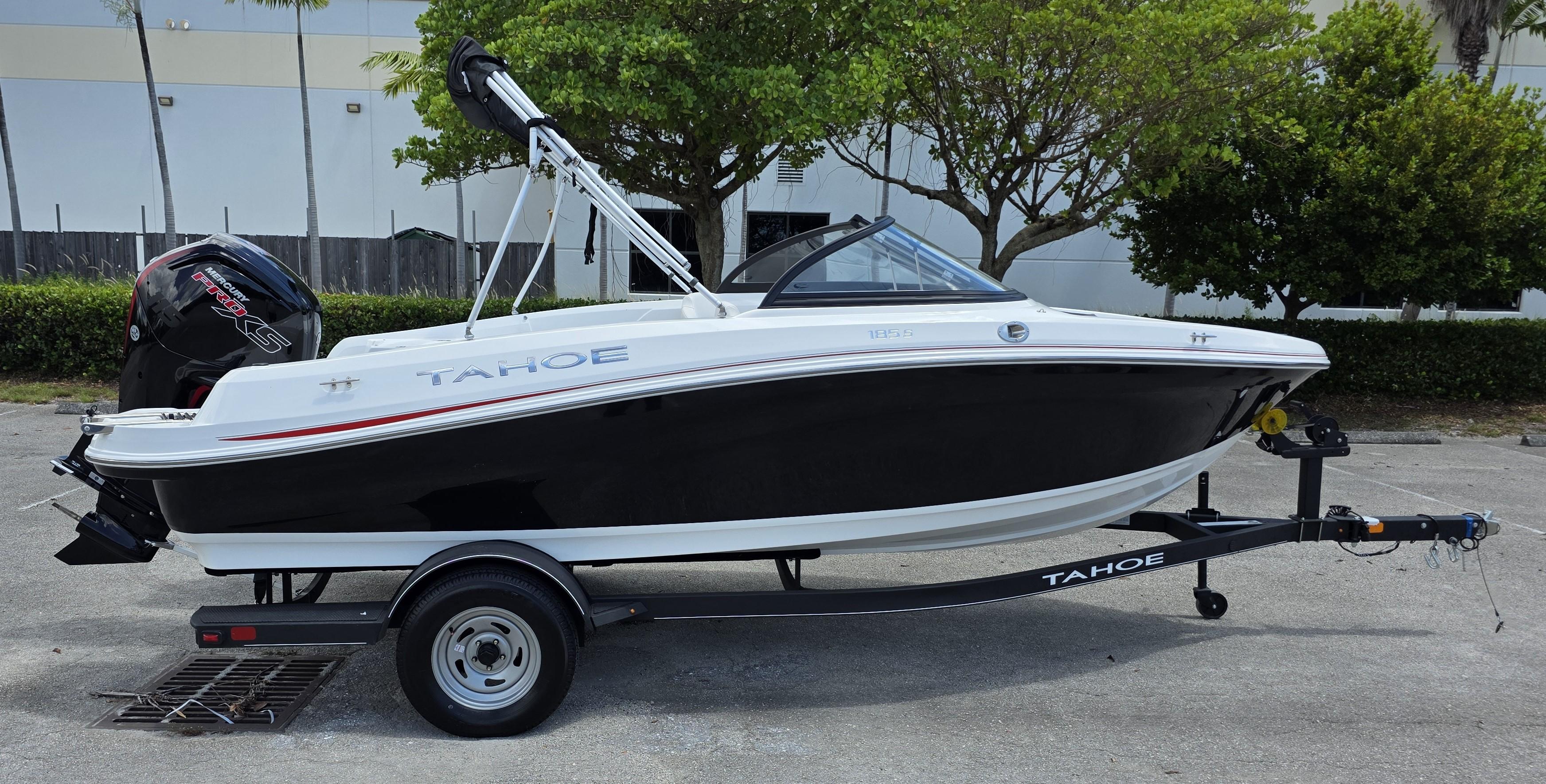 2024 Tahoe 185 S boat on trailer, black and white design, parked outdoors.