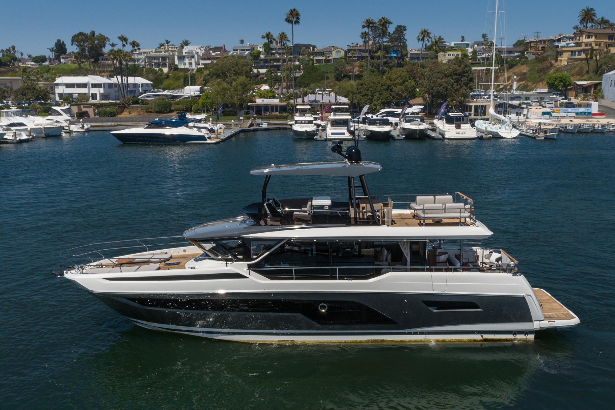 2024 Prestige X60 yacht cruising in a marina with luxury boats and waterfront homes.