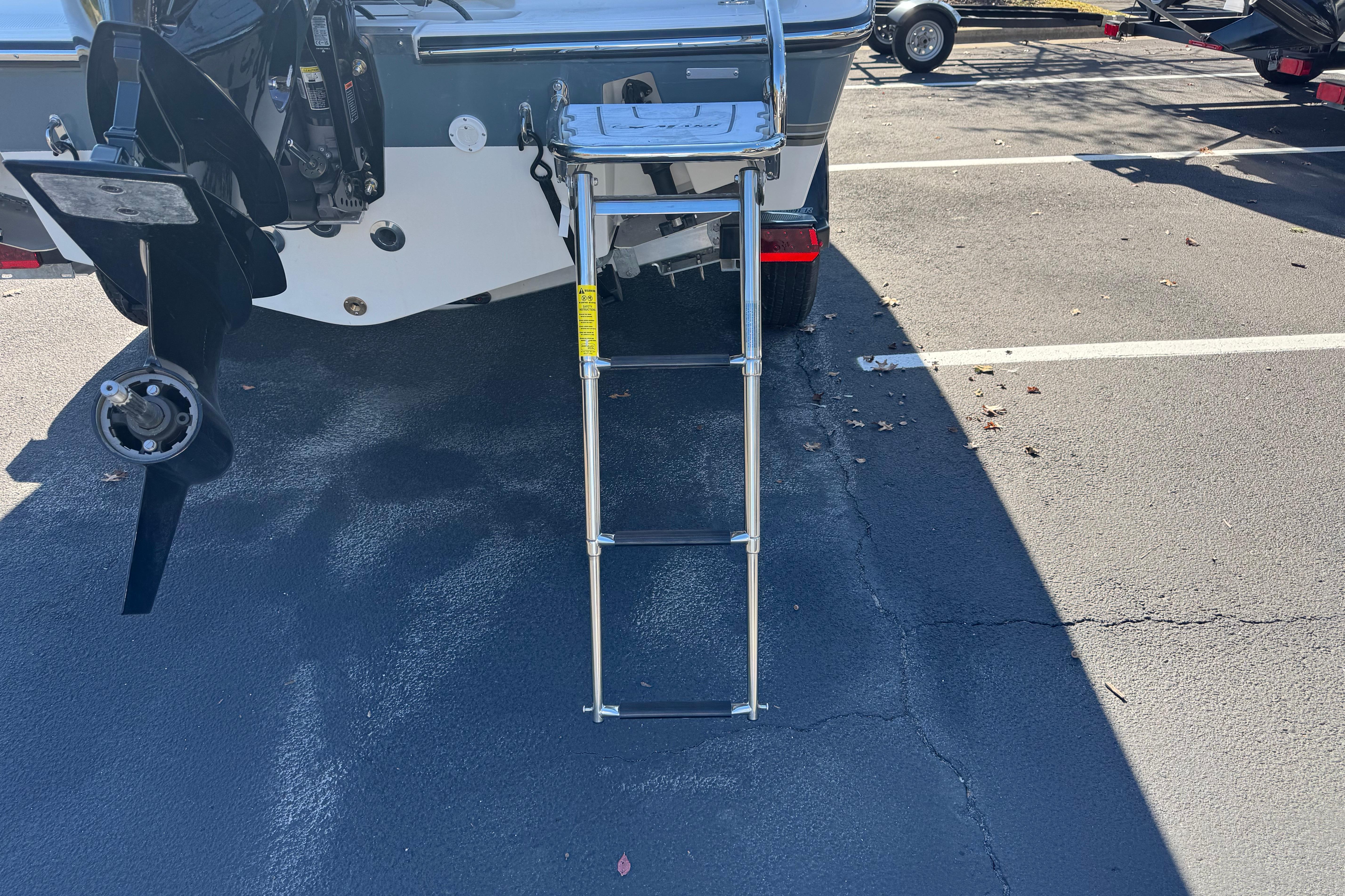 Rear view of 2026 Mako 214 Center Console boat with ladder and propeller.