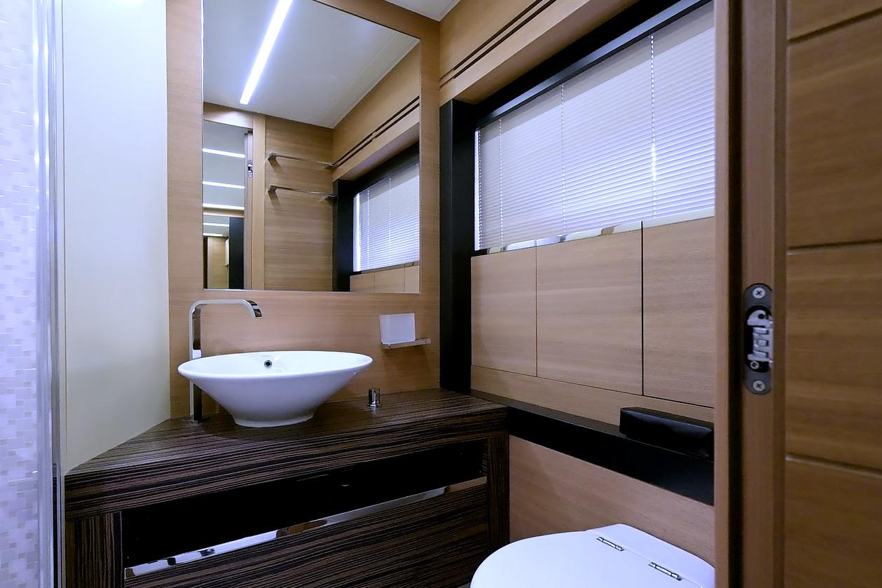 Luxurious bathroom interior on a 2015 Pershing 92 yacht, featuring modern sink and wooden accents.