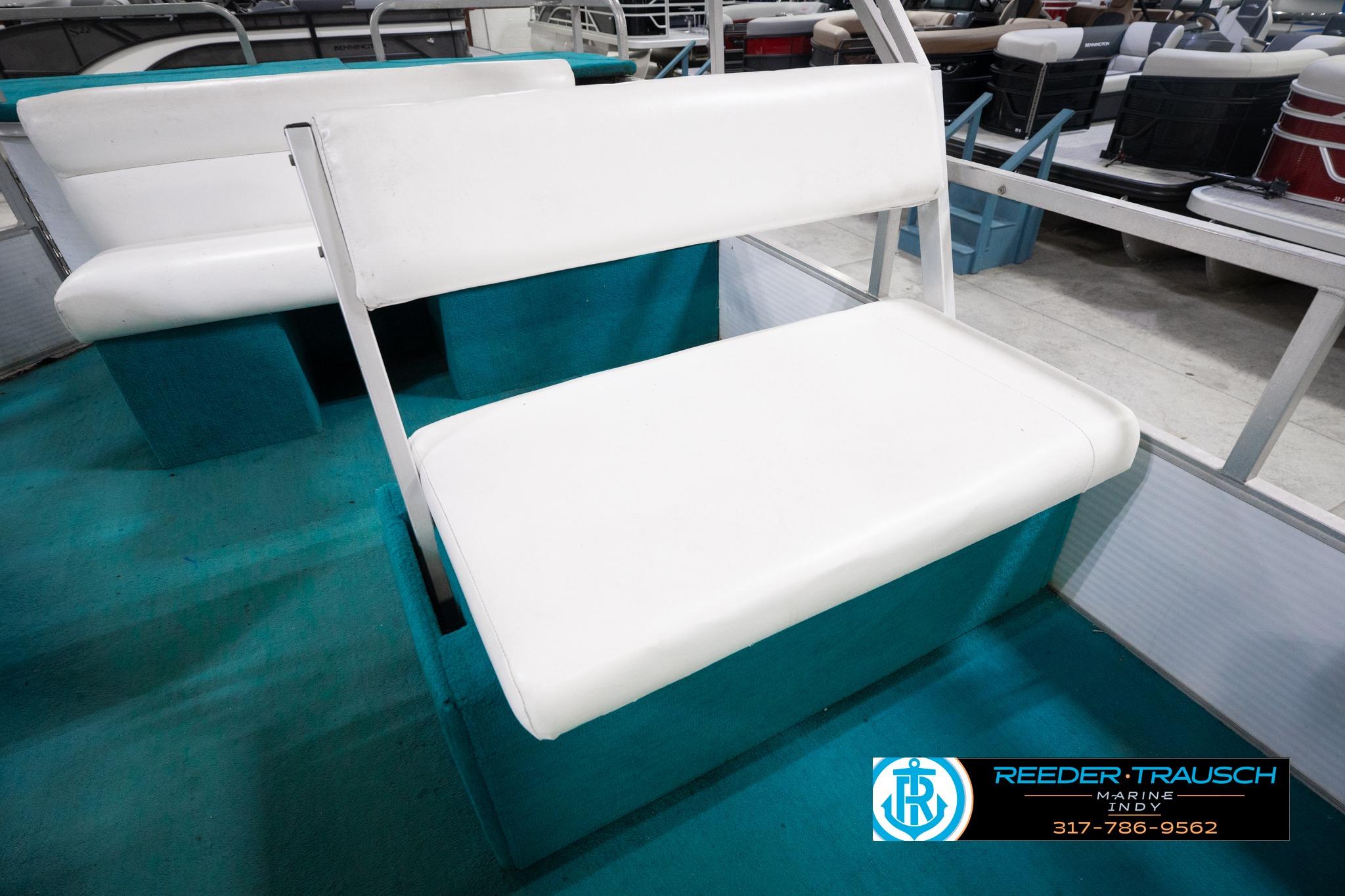 White bench seat on 1992 Godfrey Sweetwater boat, teal flooring, showroom setting.