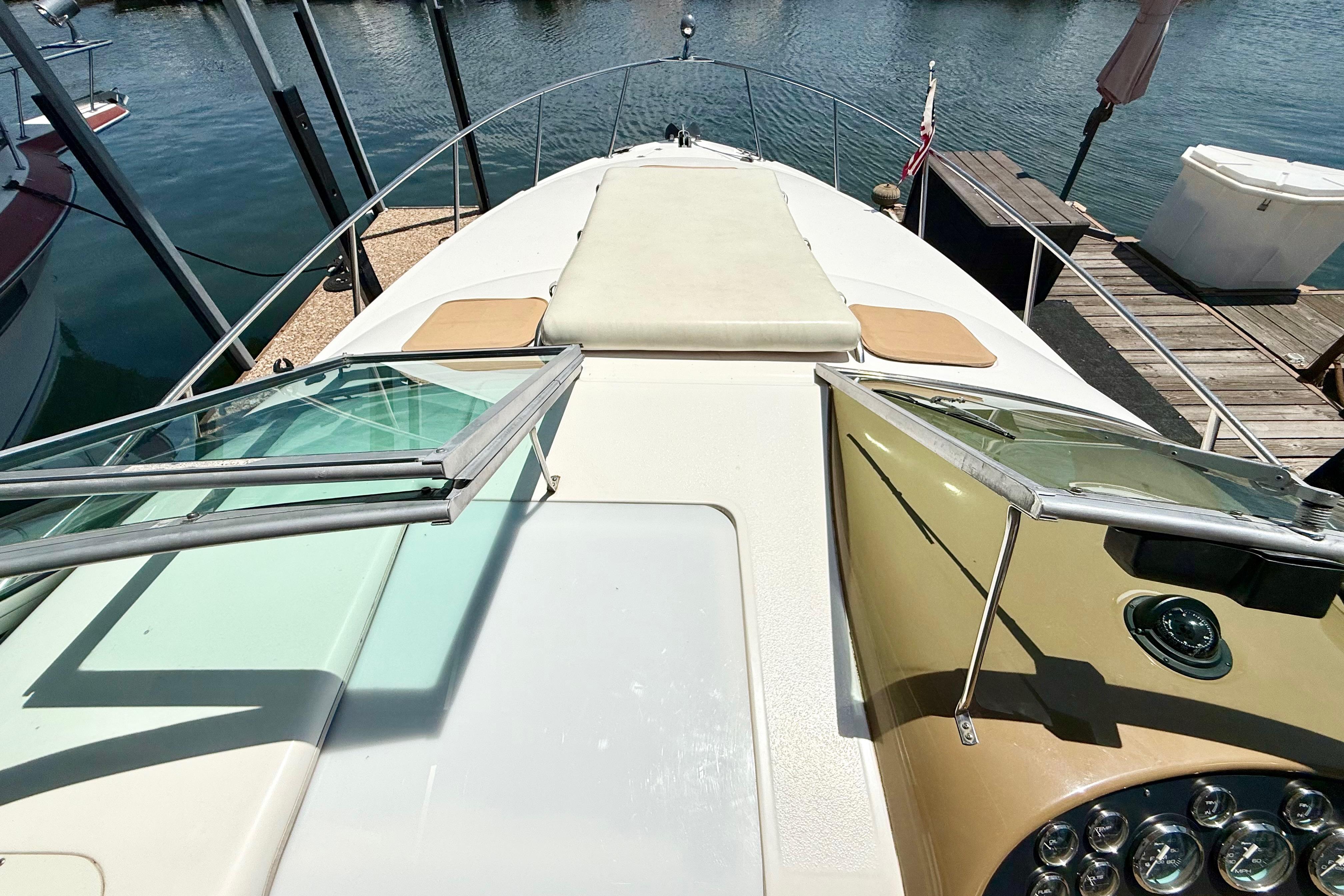 1999 Chaparral Signature 300 boat deck with open windshield, docked at marina.