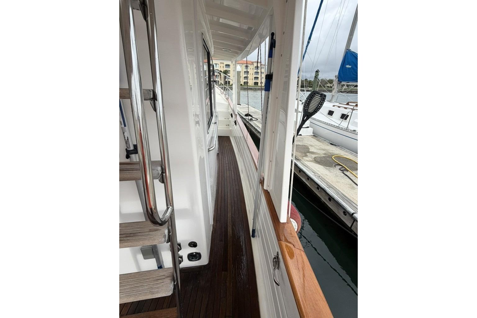 Side deck view of 2005 Kadey-Krogen 44 yacht, featuring wooden flooring and stainless steel railings.