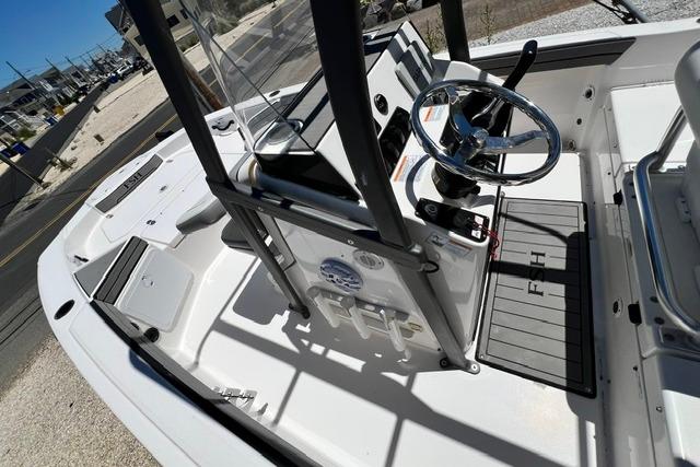 2019 Yamaha Boats 190 FSH Sport interior with steering wheel and console, docked outdoors.