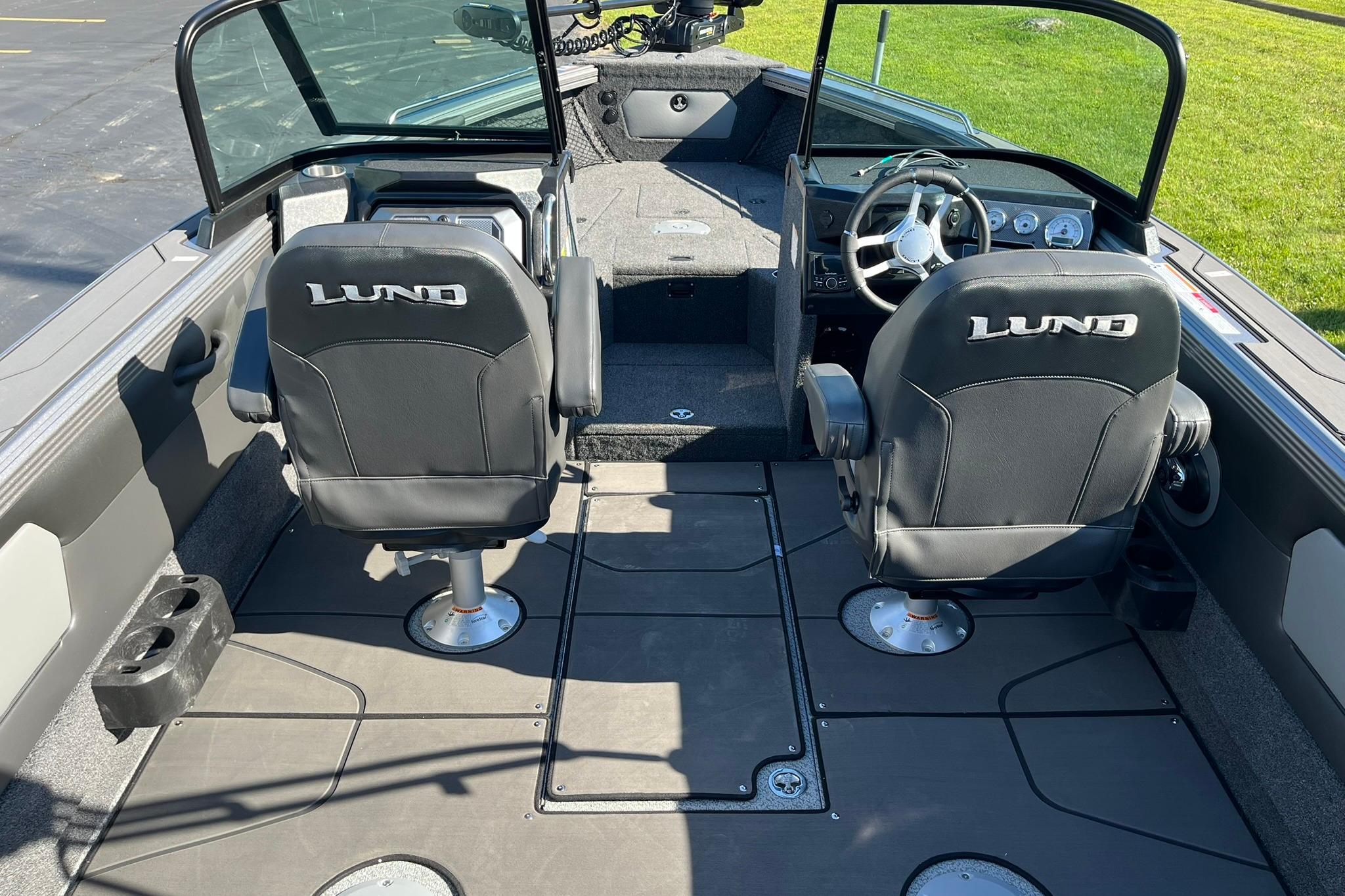 2026 Lund 2275 Baron boat interior with dual seats and steering wheel.