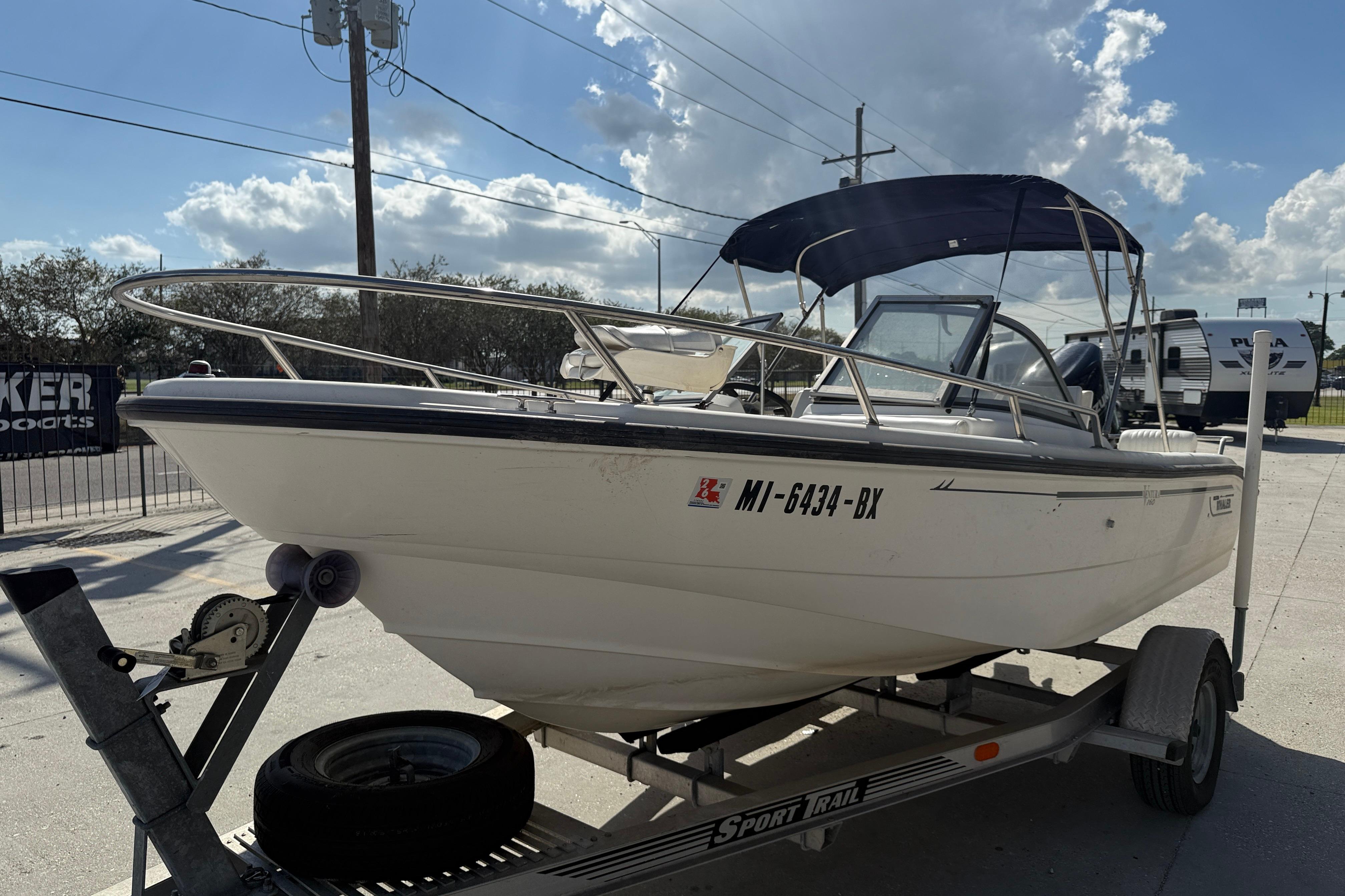 2002 Boston Whaler Ventura 160 boat on trailer under clear sky.
