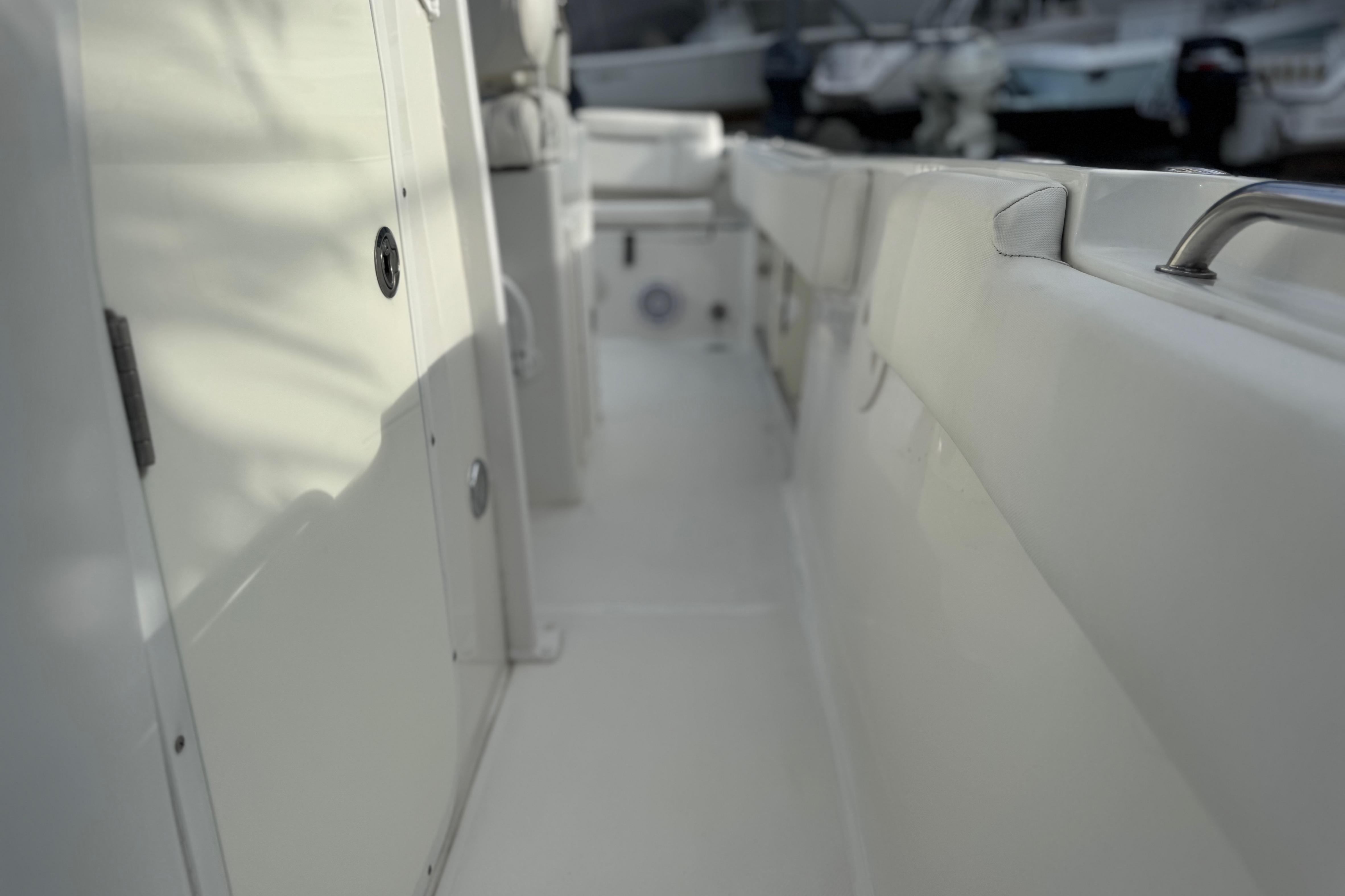 2019 Sea Hunt Ultra 235 SE boat interior with white seating and storage compartments.