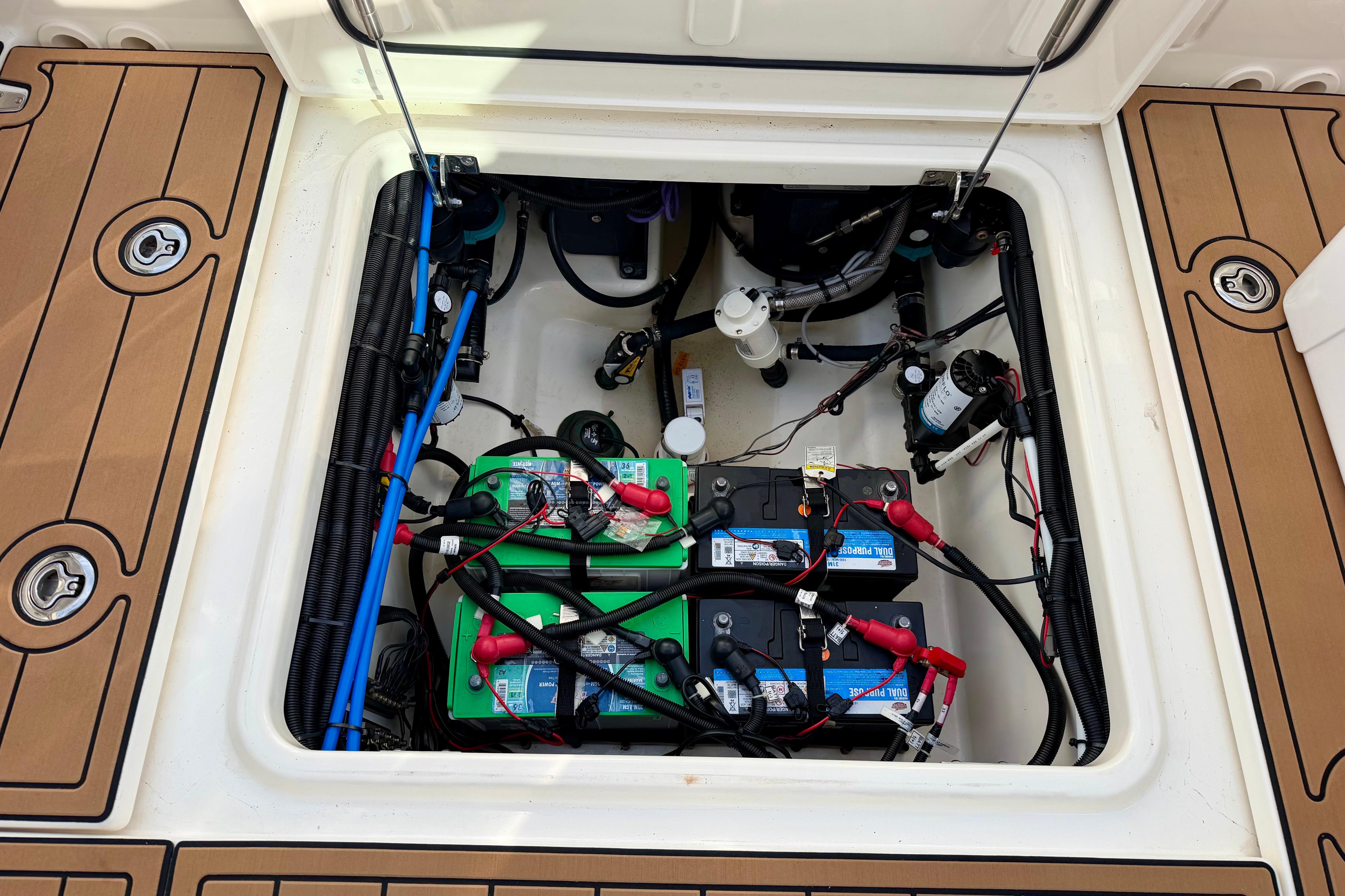 Battery compartment of a 2022 Boston Whaler 280 Vantage boat, showcasing wiring and components.
