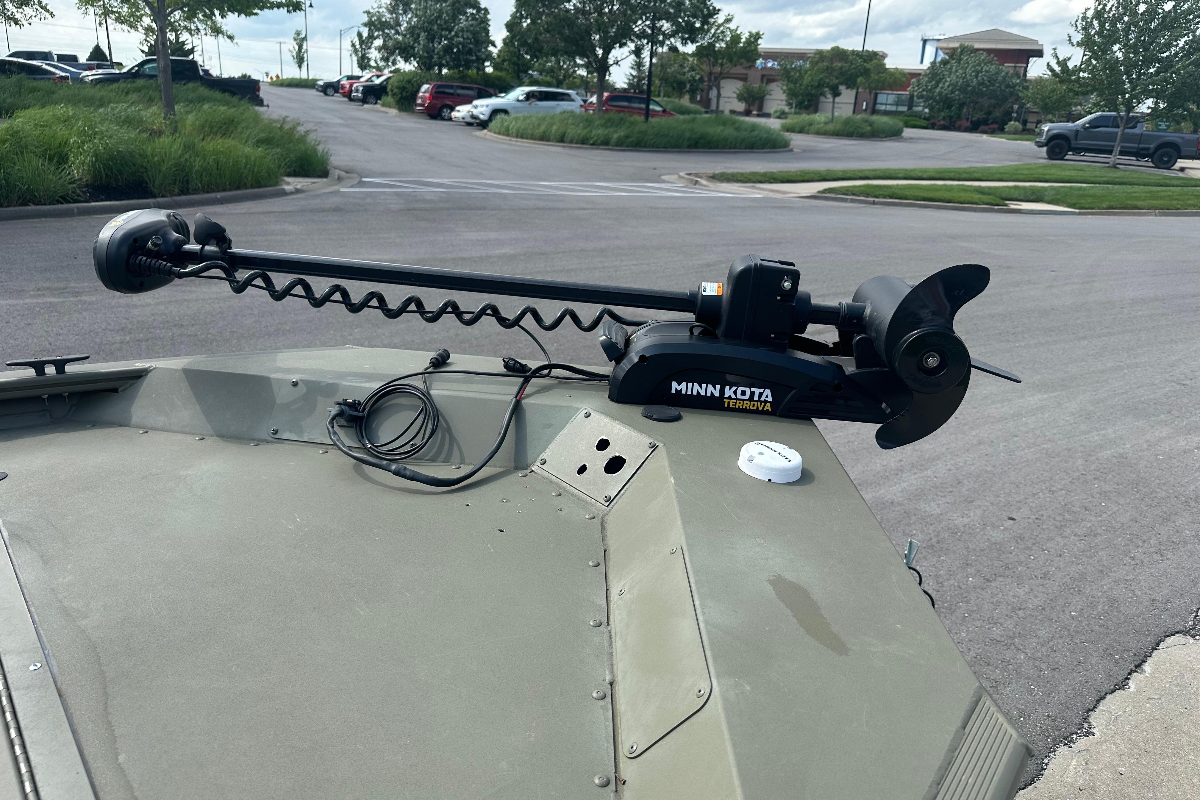 2024 Tracker Grizzly 1648 SC with Minn Kota Terrova trolling motor in parking lot.
