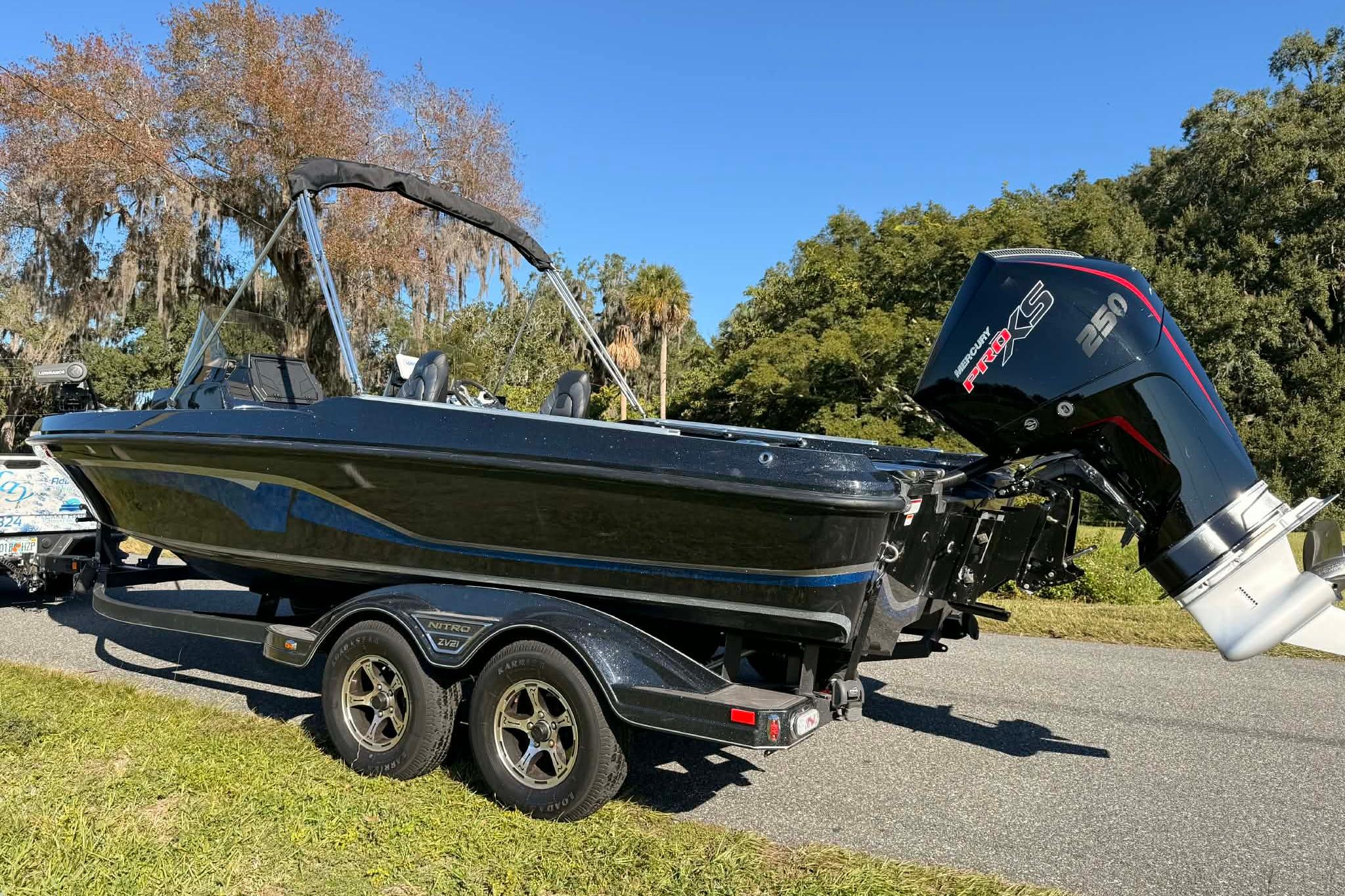 2024 Nitro ZV21 boat with Mercury Pro XS engine on a trailer, parked outdoors.